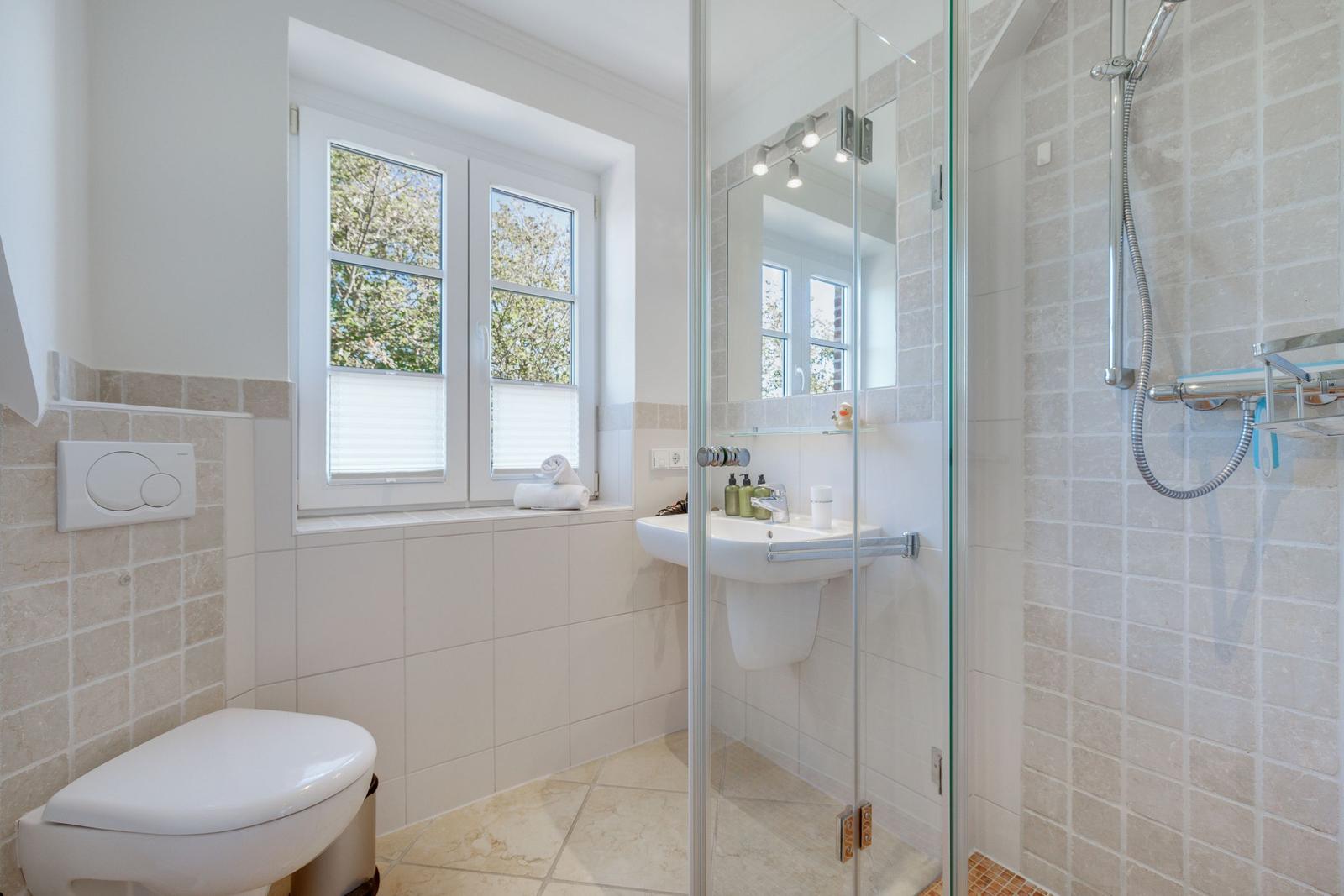 Badezimmer mit Dusche, Waschbecken und Fenster