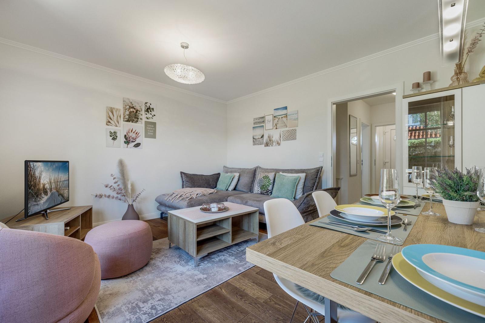Wohn- und Essbereich mit Sofa, Esstisch und Fernseher.