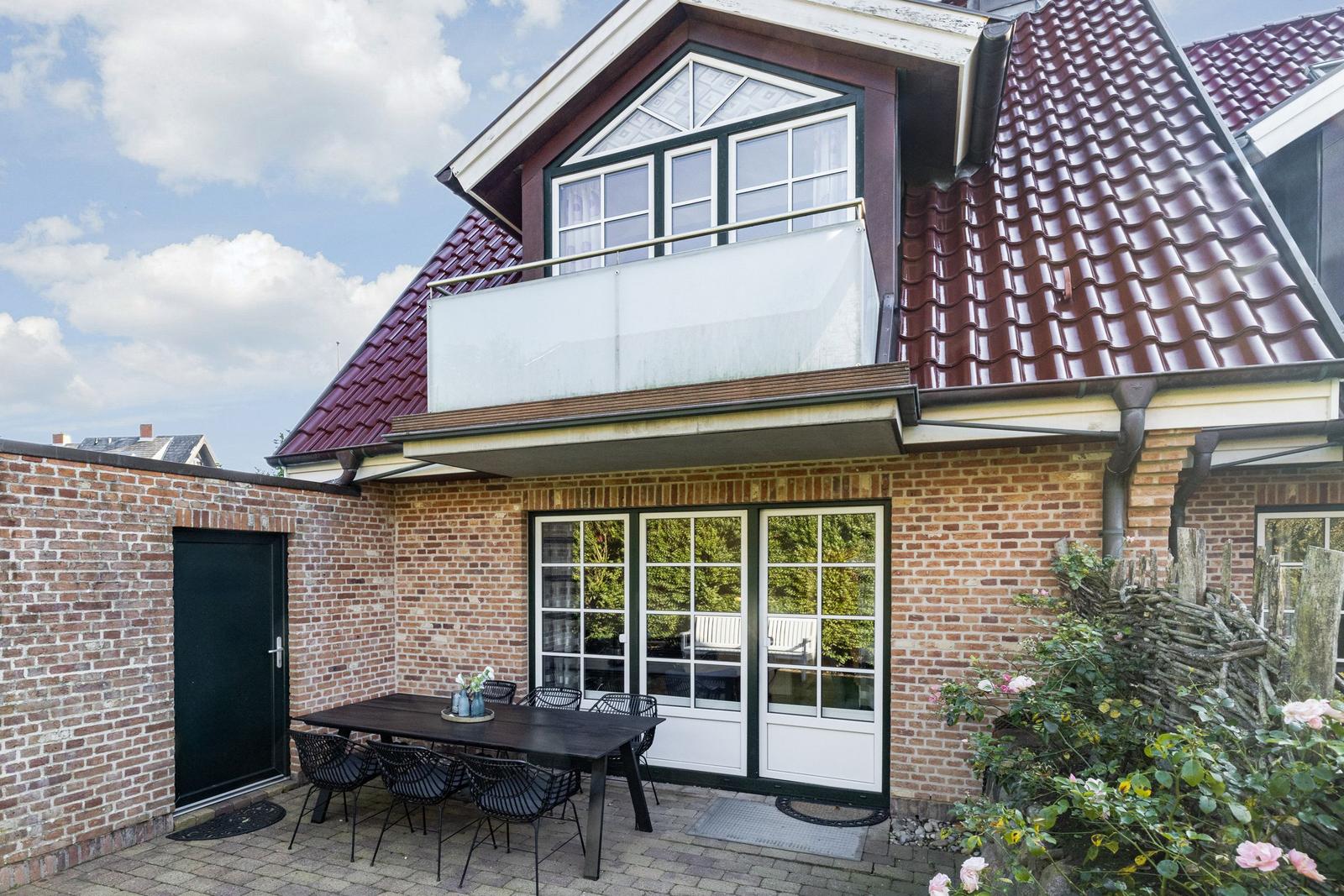 House with balcony, terrace, and outdoor dining area.