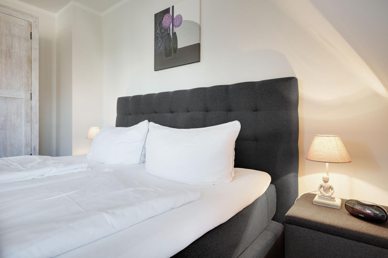 Bedroom with bed, nightstand, and wall art.