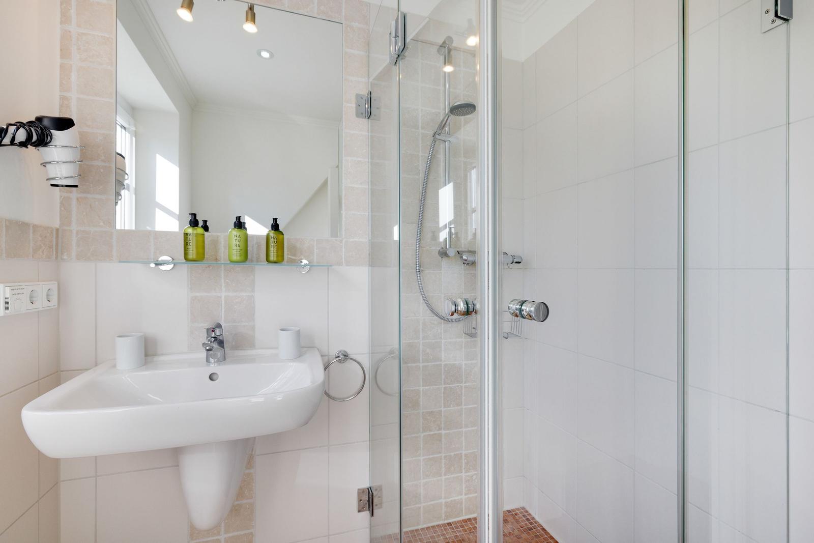 Bathroom with shower, sink, and mirror