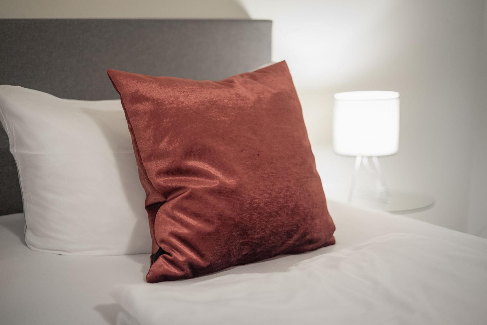 Bed headboard with pillows and bedside lamp
