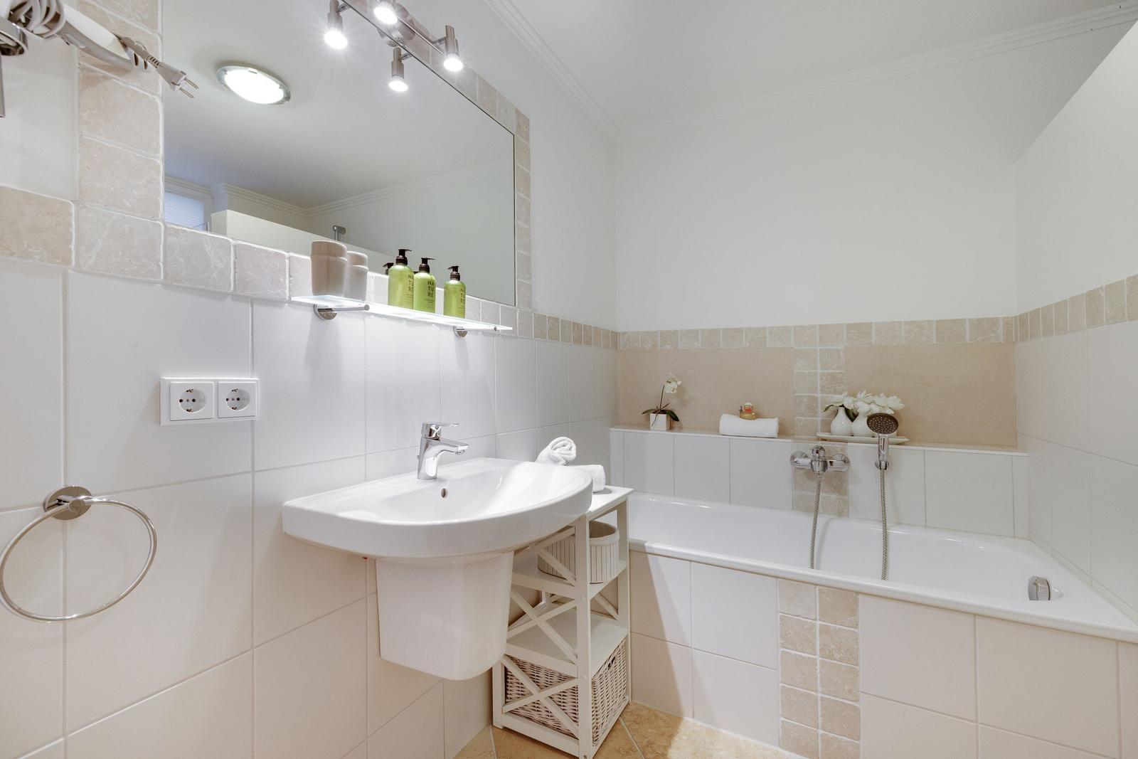 Bathroom with bathtub, sink, and mirror