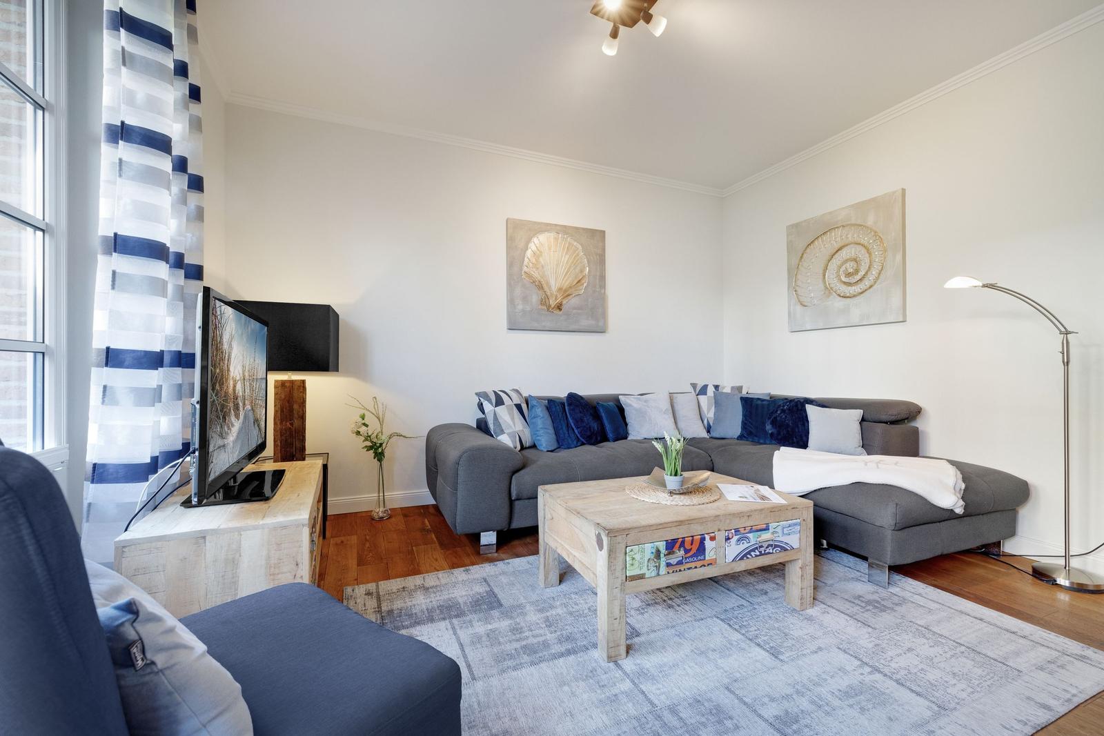 Living room with gray sofa, wooden table, and wall art