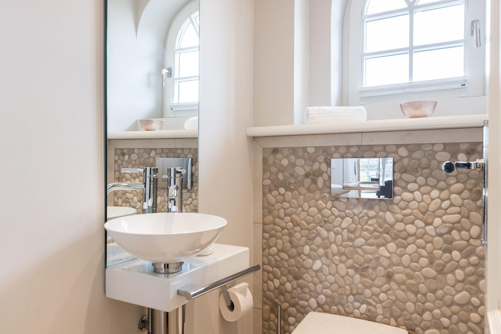 Bathroom with sink, mirror, and stone wall