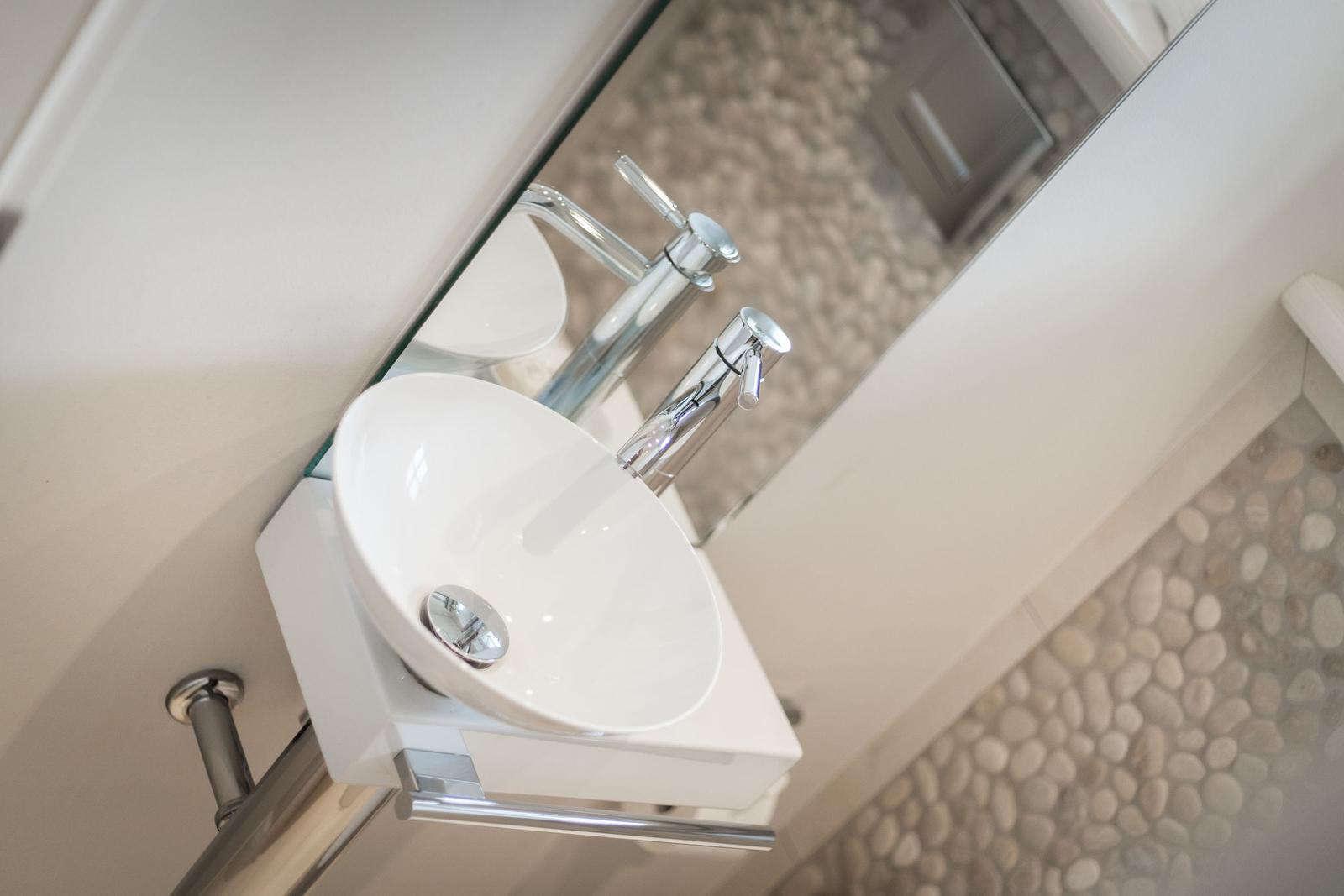 Sink with mirror and pebble tile wall