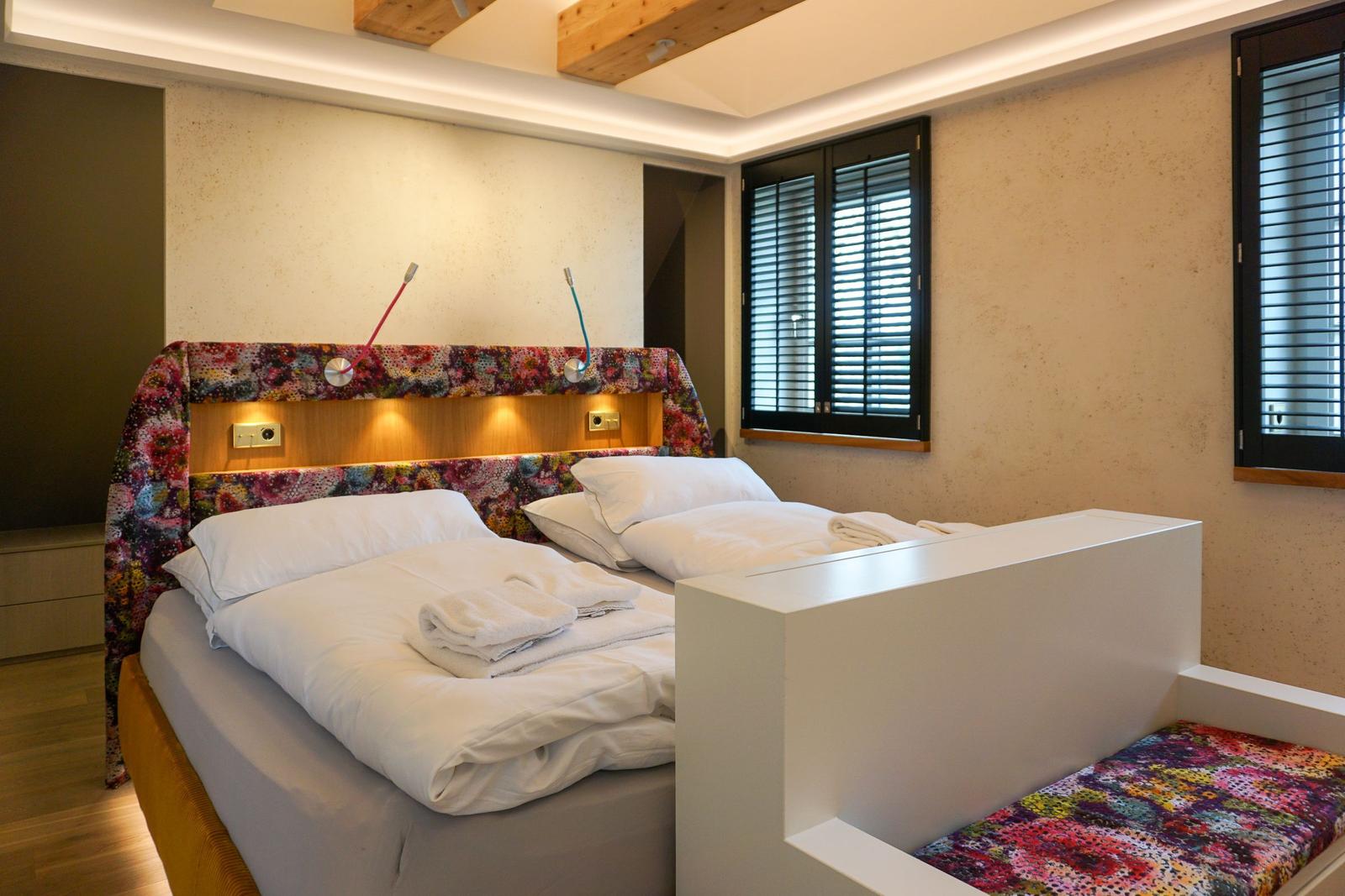 Bedroom with bed, headboard, and windows