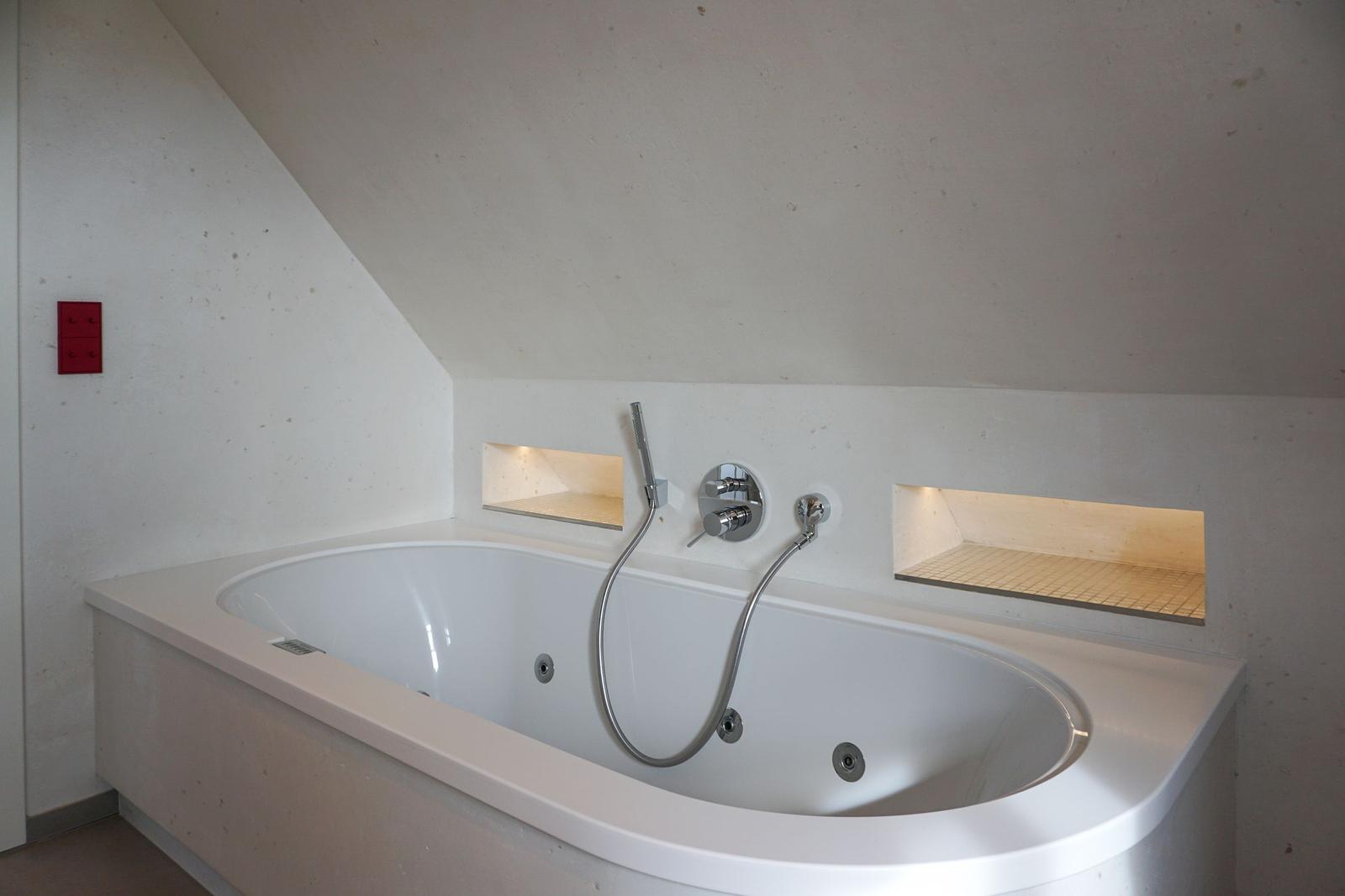Shower tub with integrated whirlpool and built-in shelves.