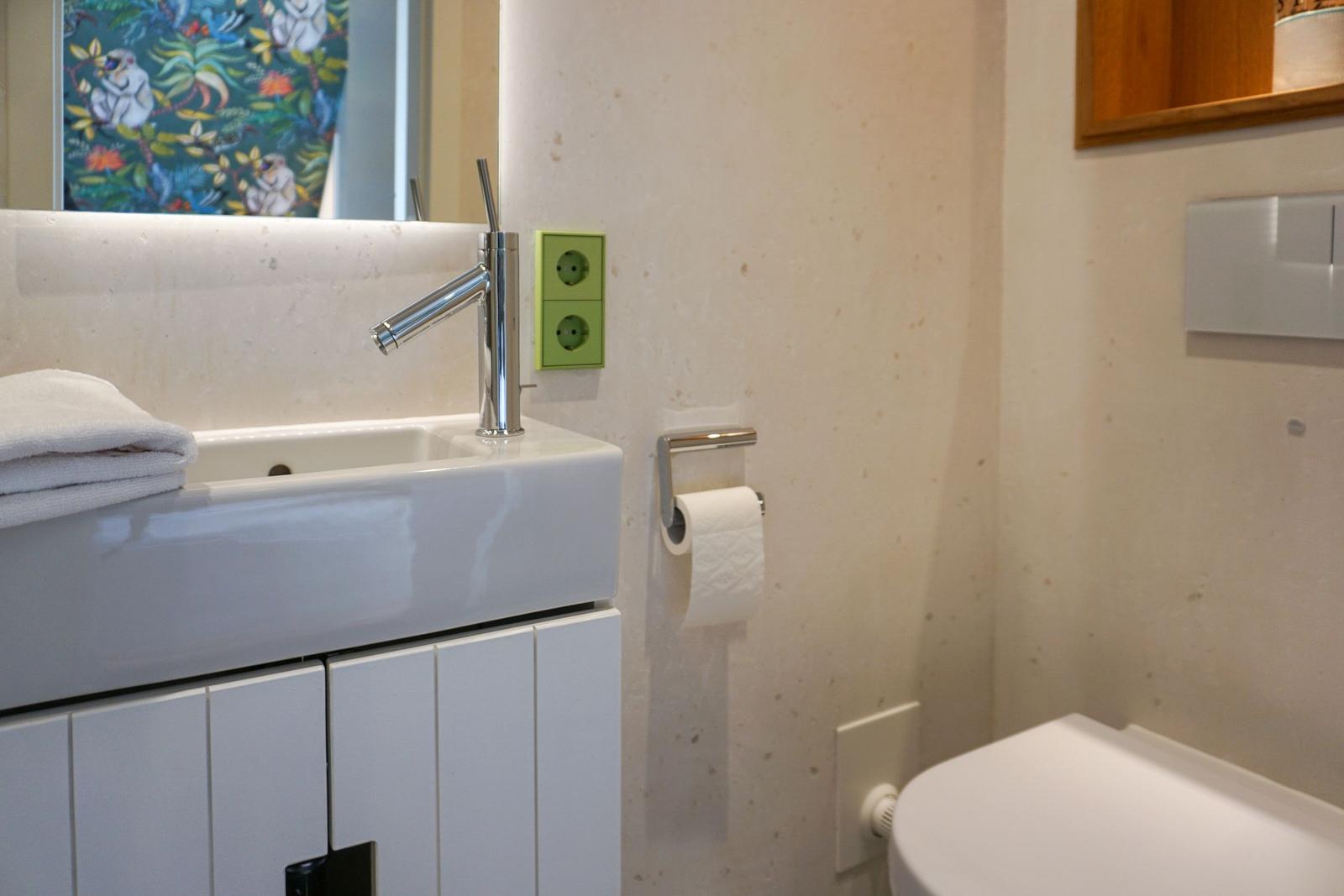 Bathroom with sink, mirror, and toilet.
