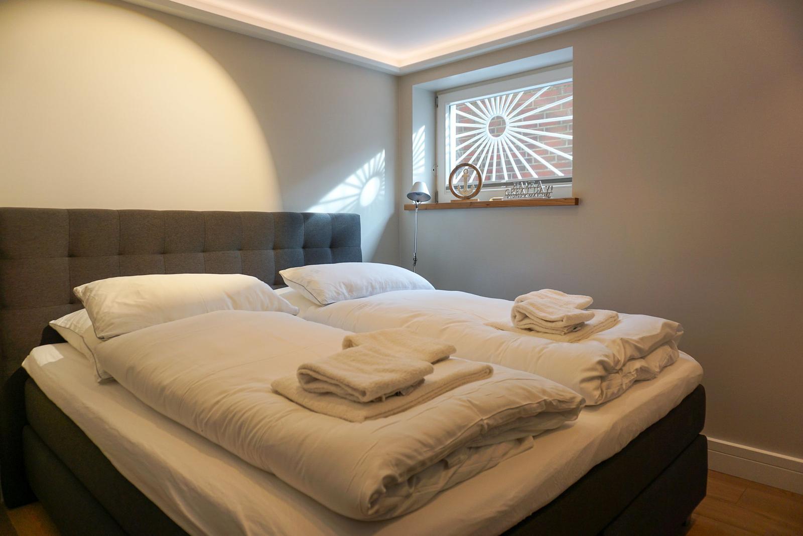 Bedroom with double bed, window, and bed linen.