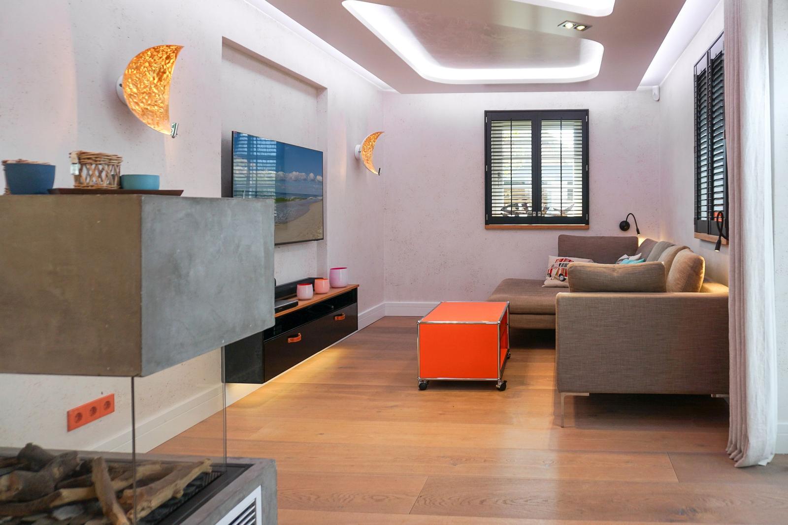 Living room with sofa, TV, and orange coffee table.
