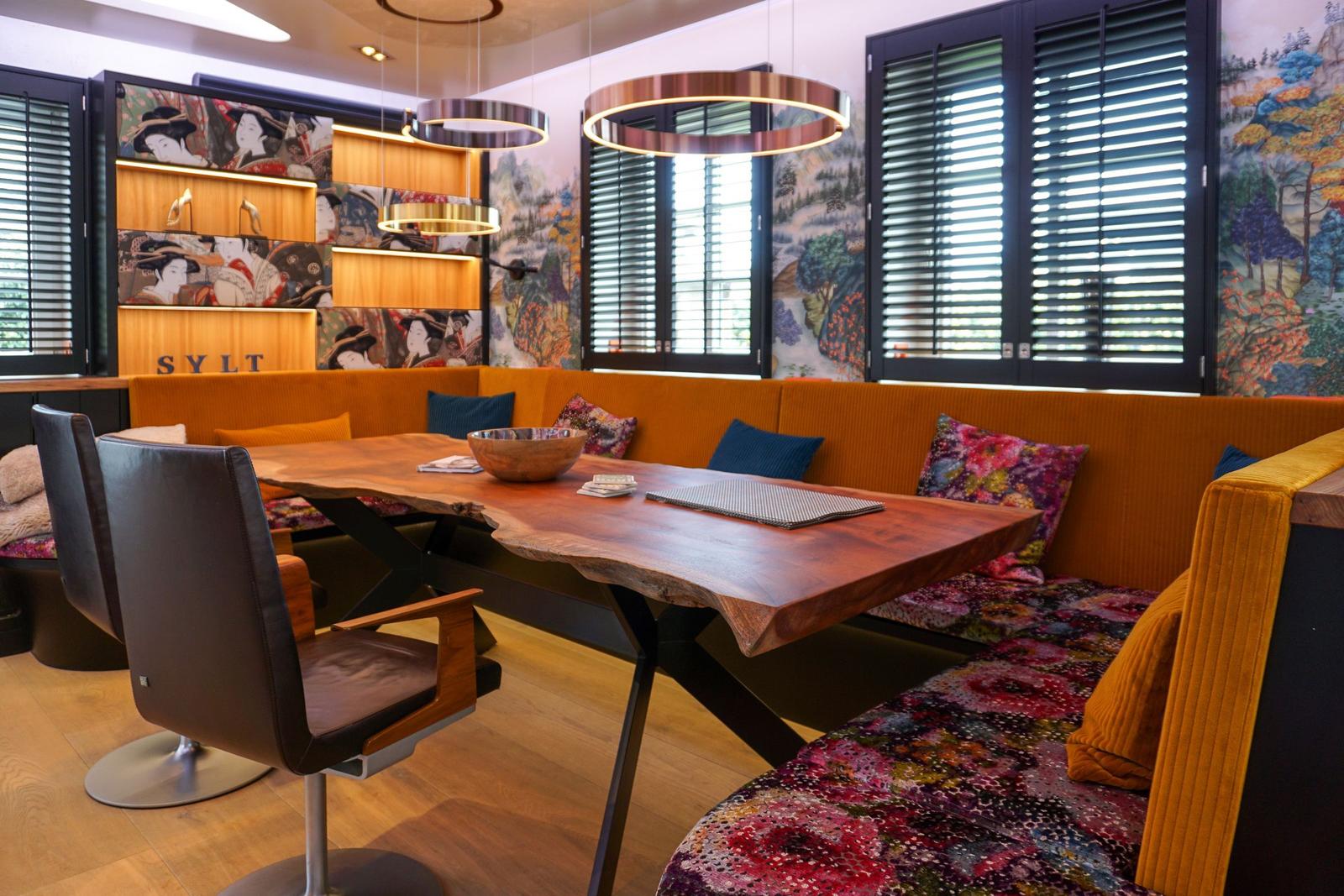 Dining area with wooden table, bench, and wall decoration.