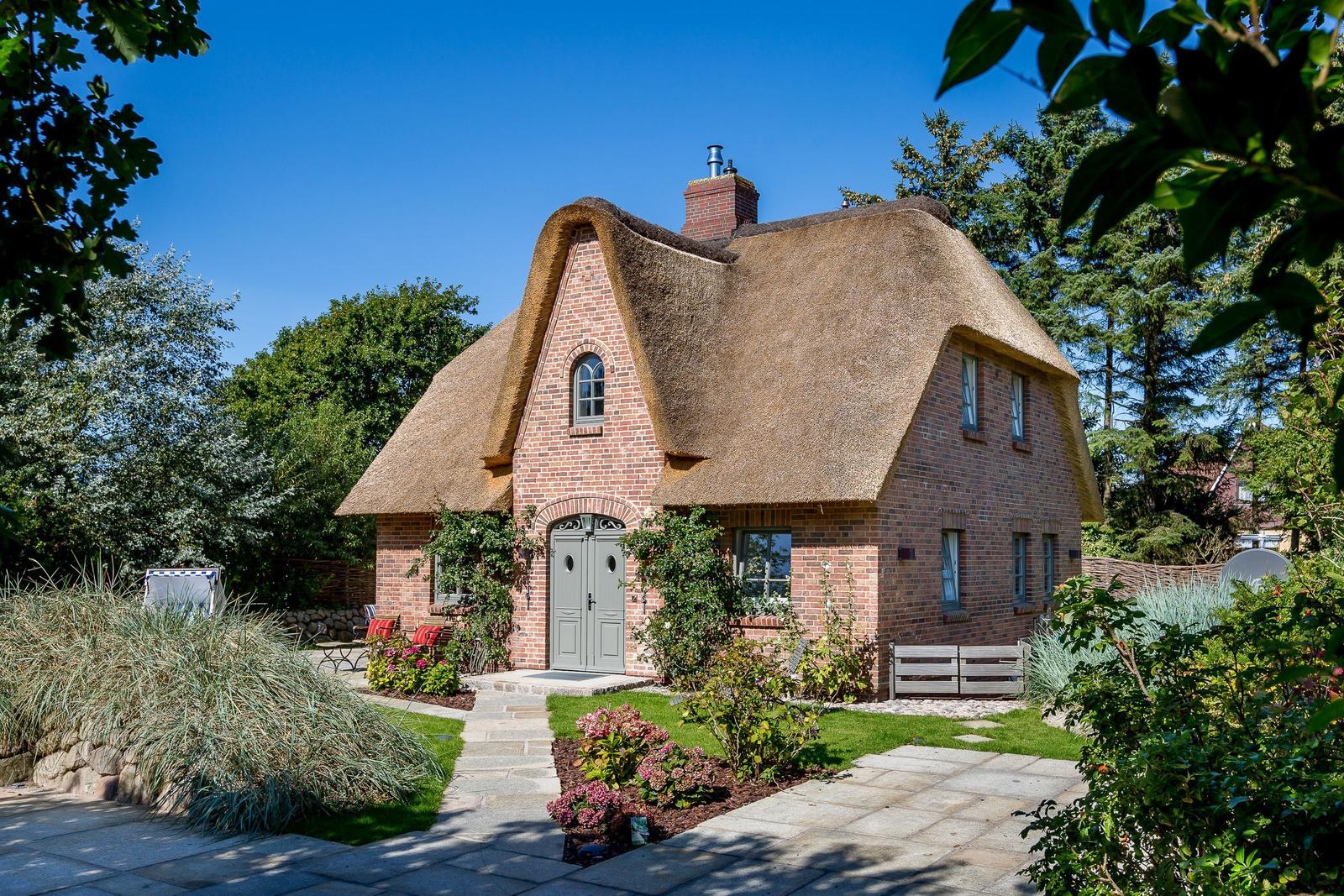 Red brick house with thatched roof and green door