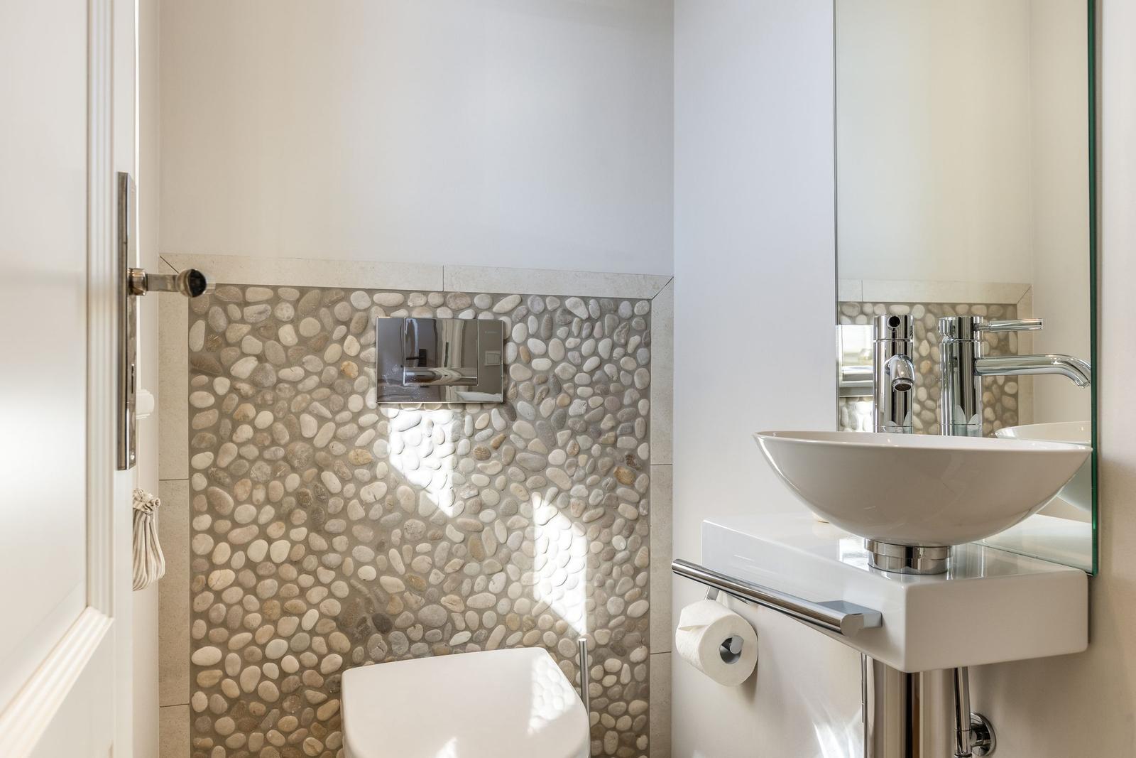 Bathroom with stone wall, sink, and mirror