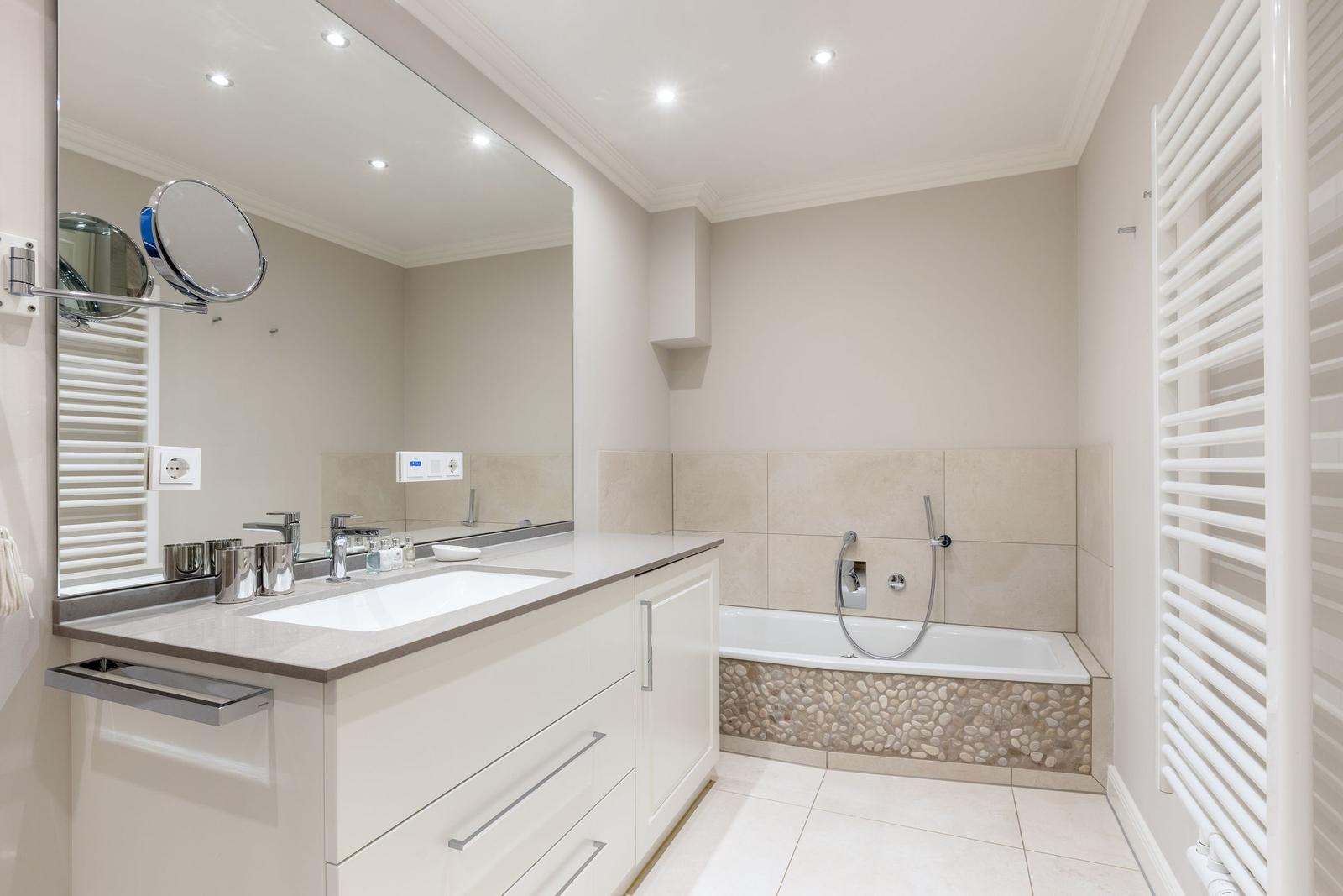 Bathroom with bathtub, sink and mirror