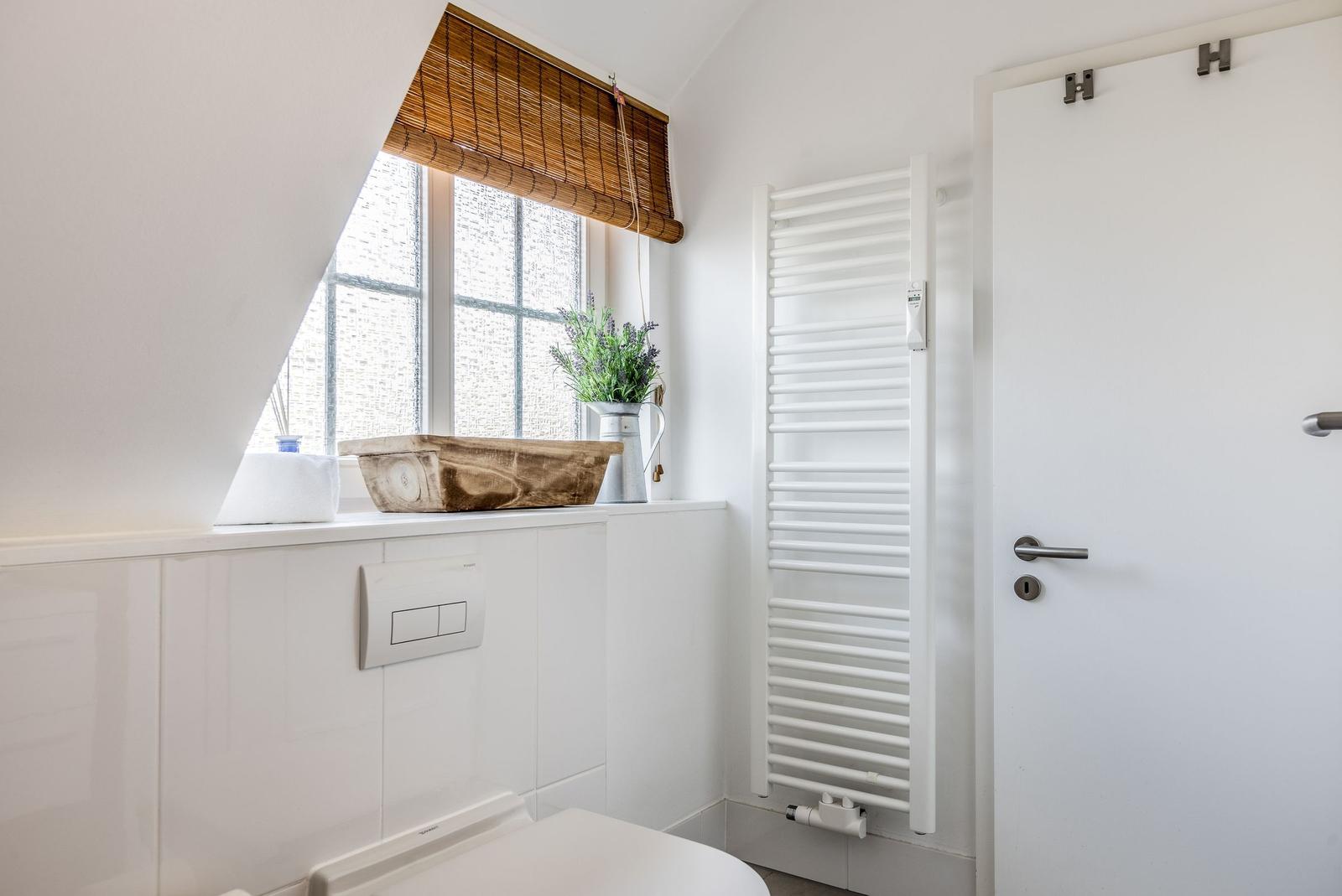 Bathroom with window, heater, and toilet