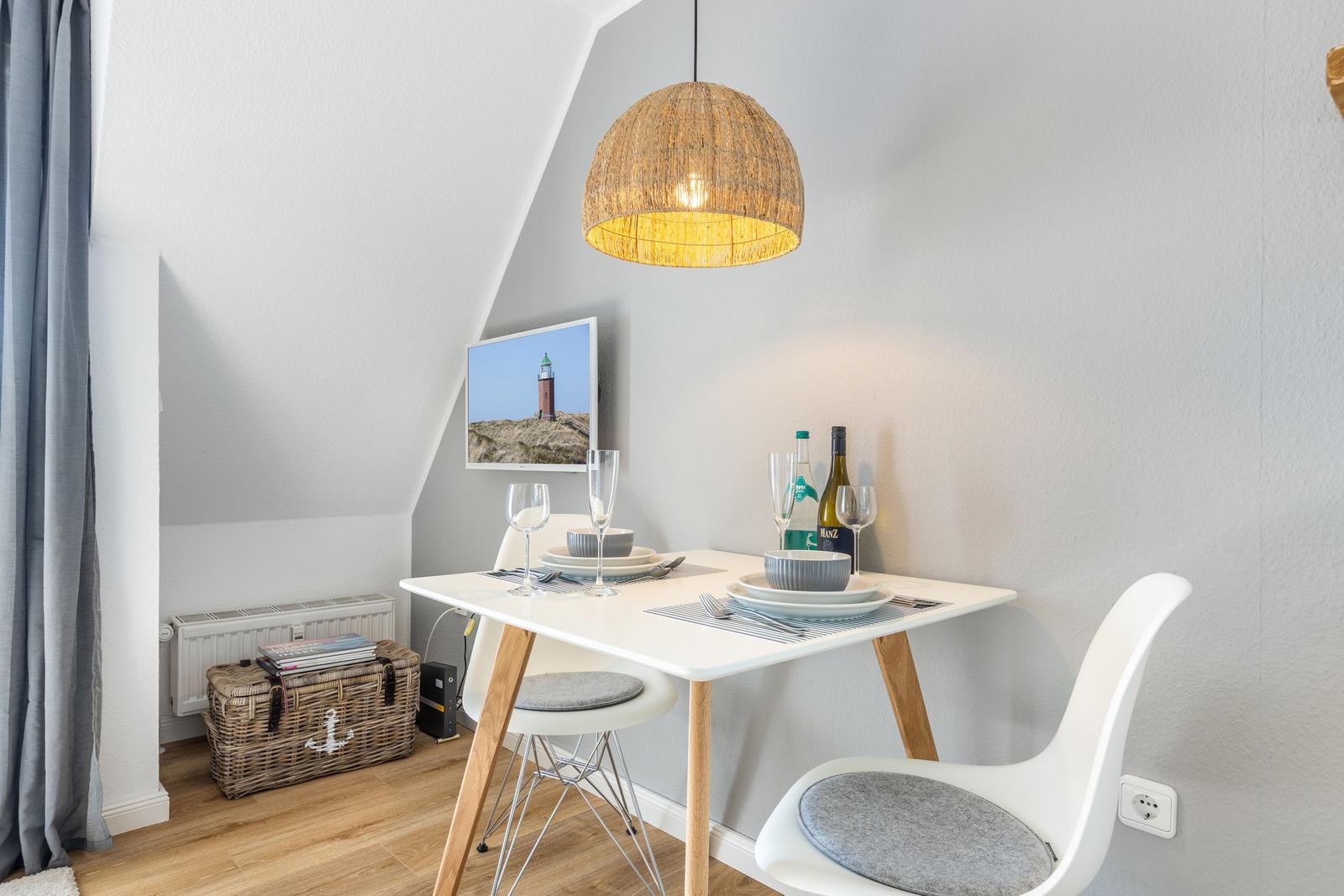 Dining area with table, chairs, and lamp under sloped ceiling