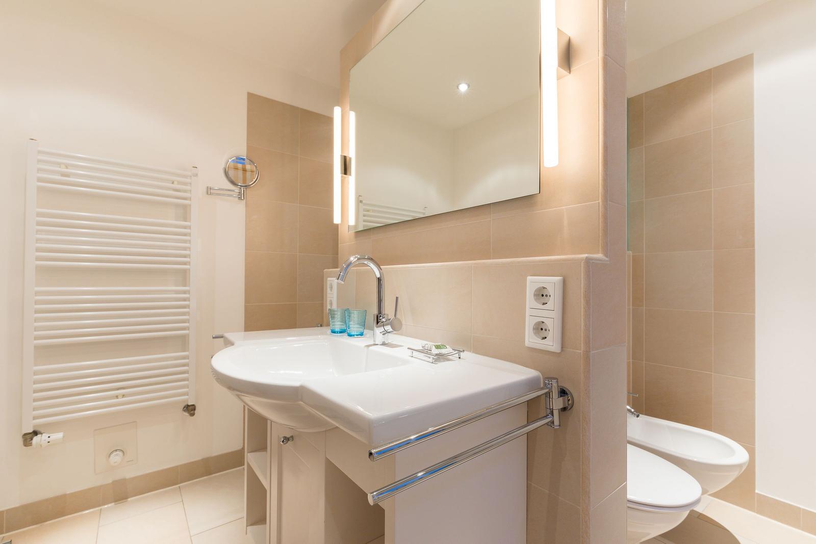 Bathroom with sink, mirror, and toilet.