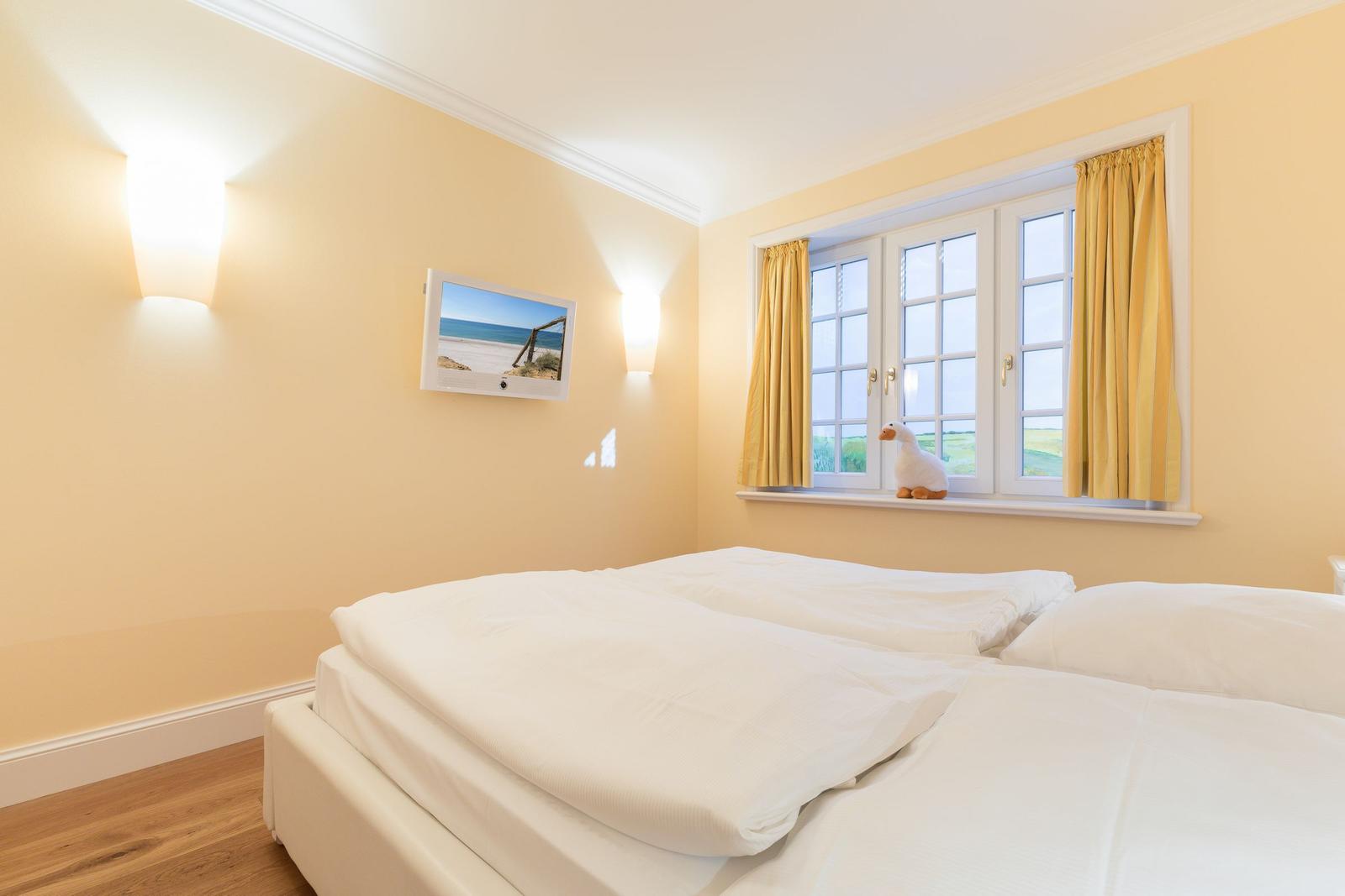Bedroom with bed, window, and wall picture.