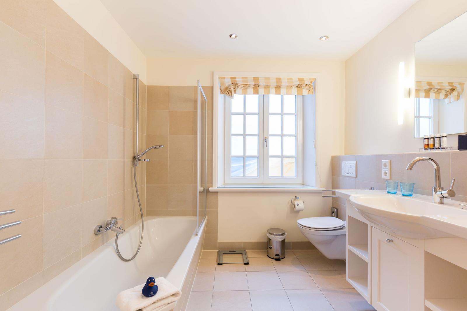Bathroom with bathtub, shower, sink, and toilet.