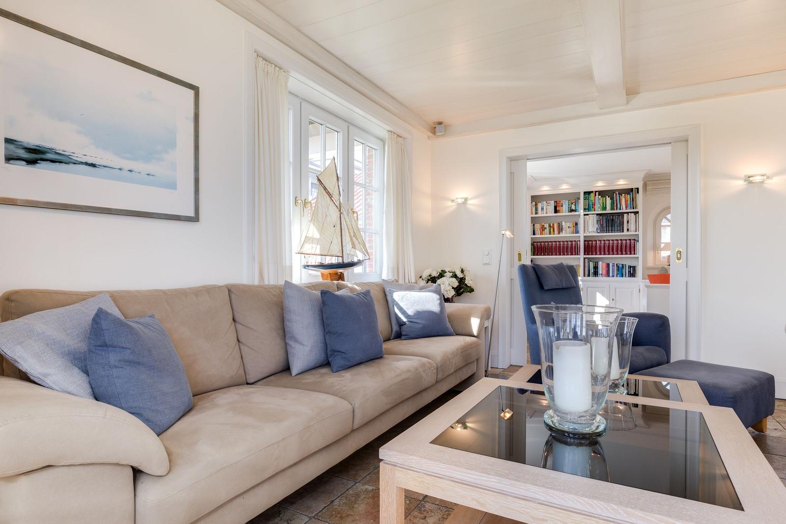 Living room with sofa, coffee table, and view into the library.