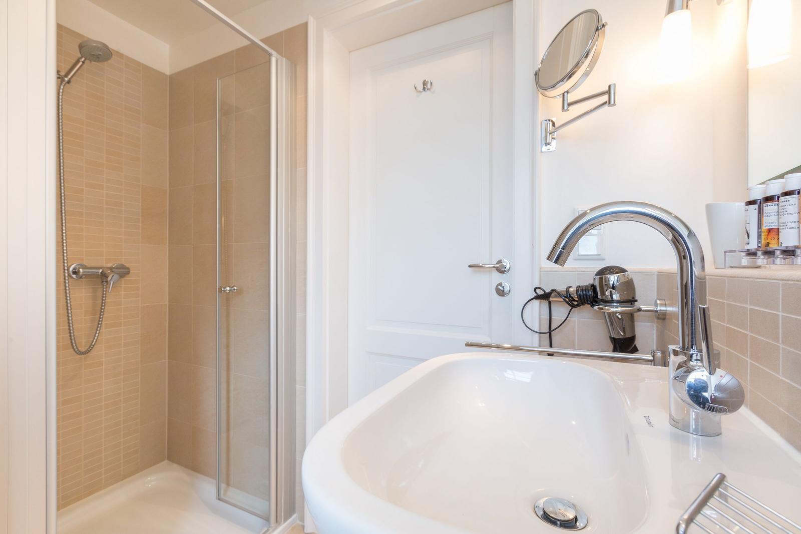 Bathroom with shower, sink, and mirror.