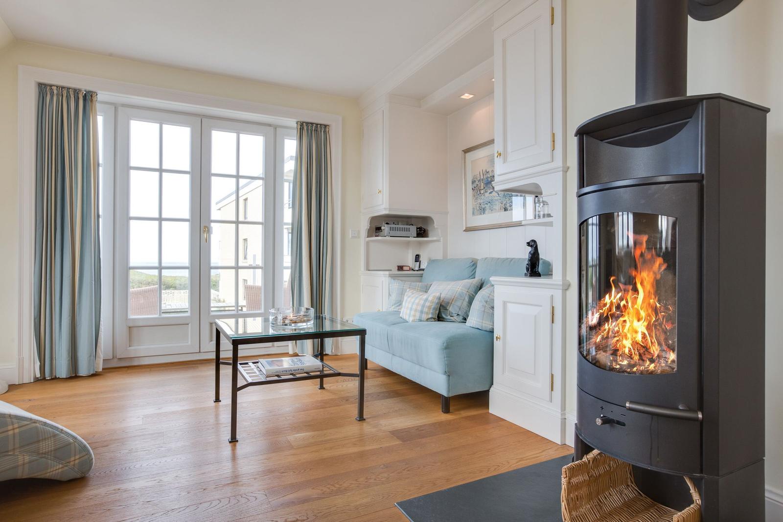 Living room with fireplace, sofa, and window view