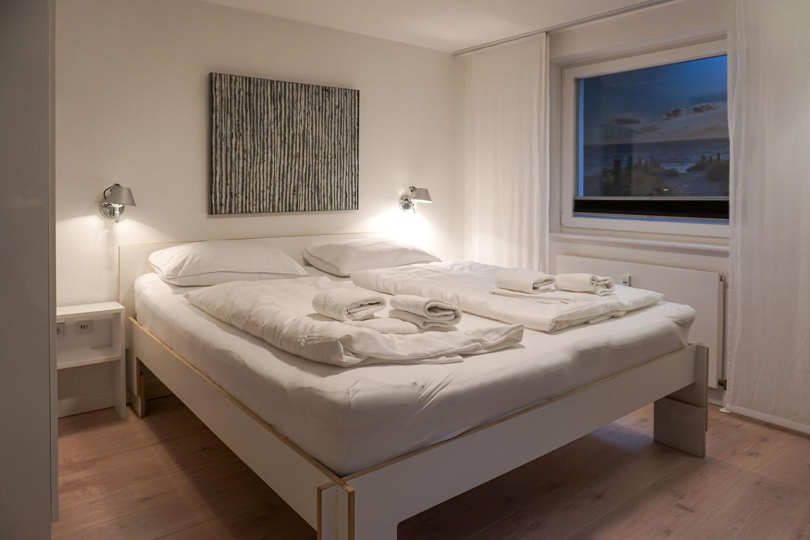Bedroom with bed, window, and wall art.