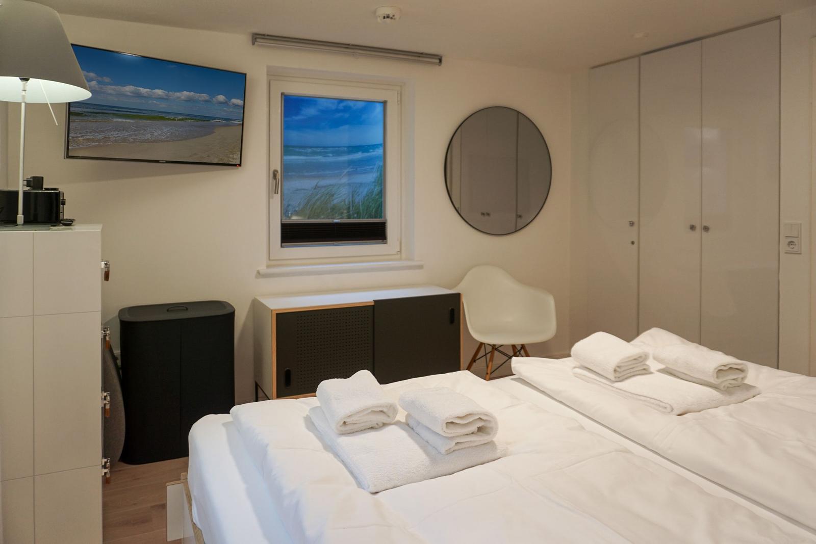 Bedroom with double bed, window, TV, and wardrobe.