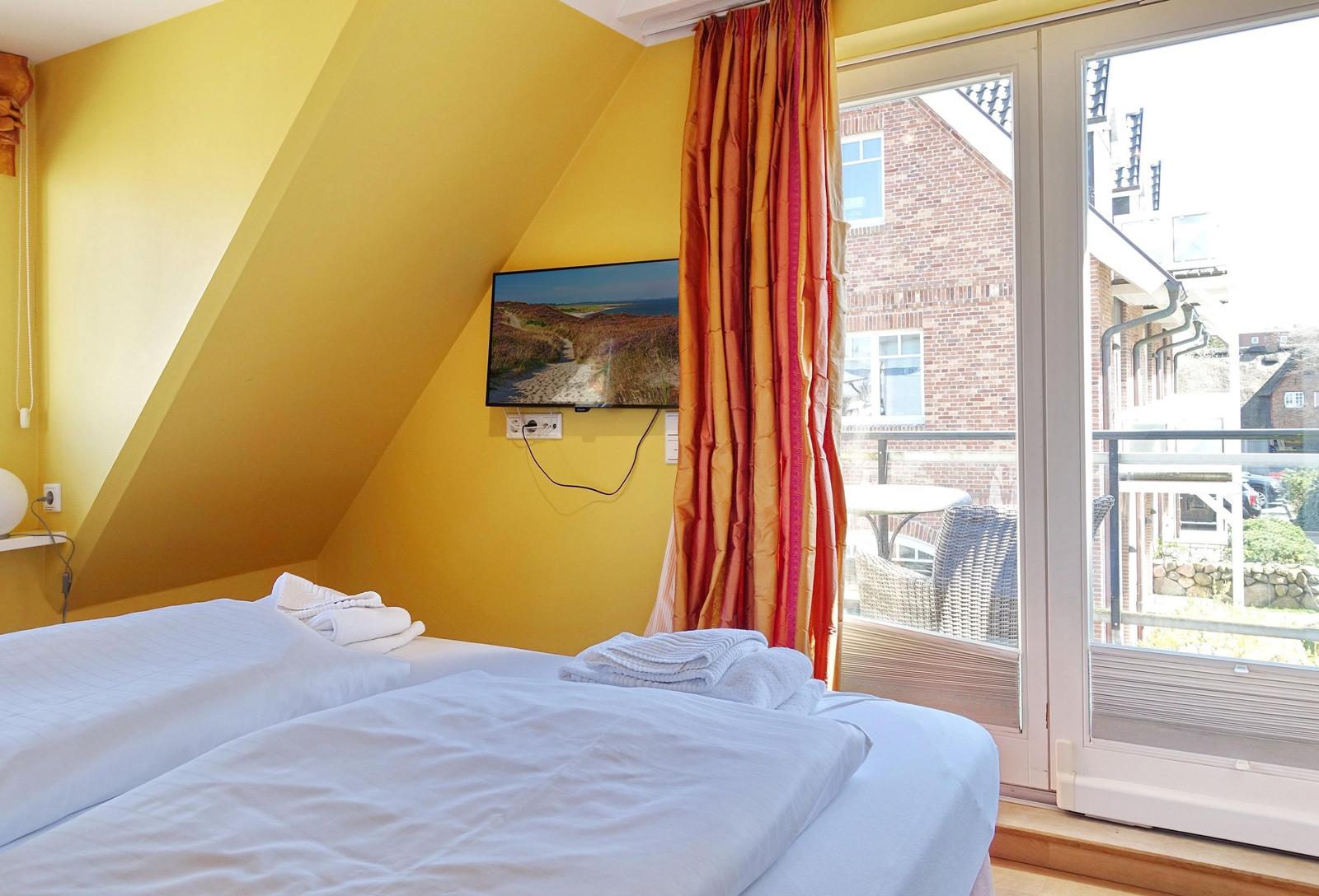 Bedroom with double bed, TV, and balcony view