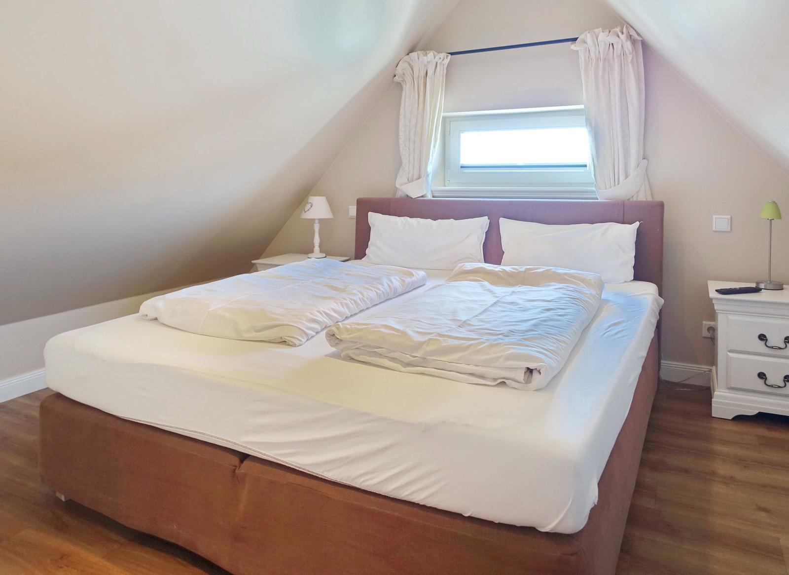 Bedroom with double bed, window, and nightstands.