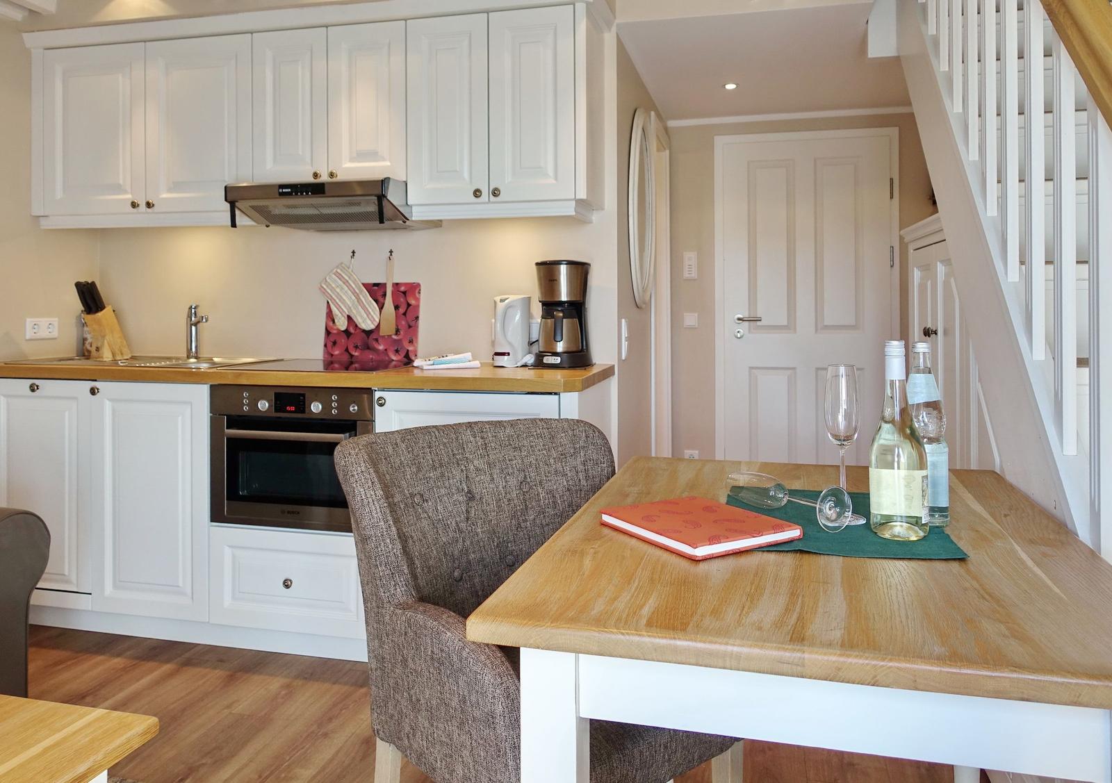 Kitchen with dining area, white cabinets, and wooden table with chairs.
