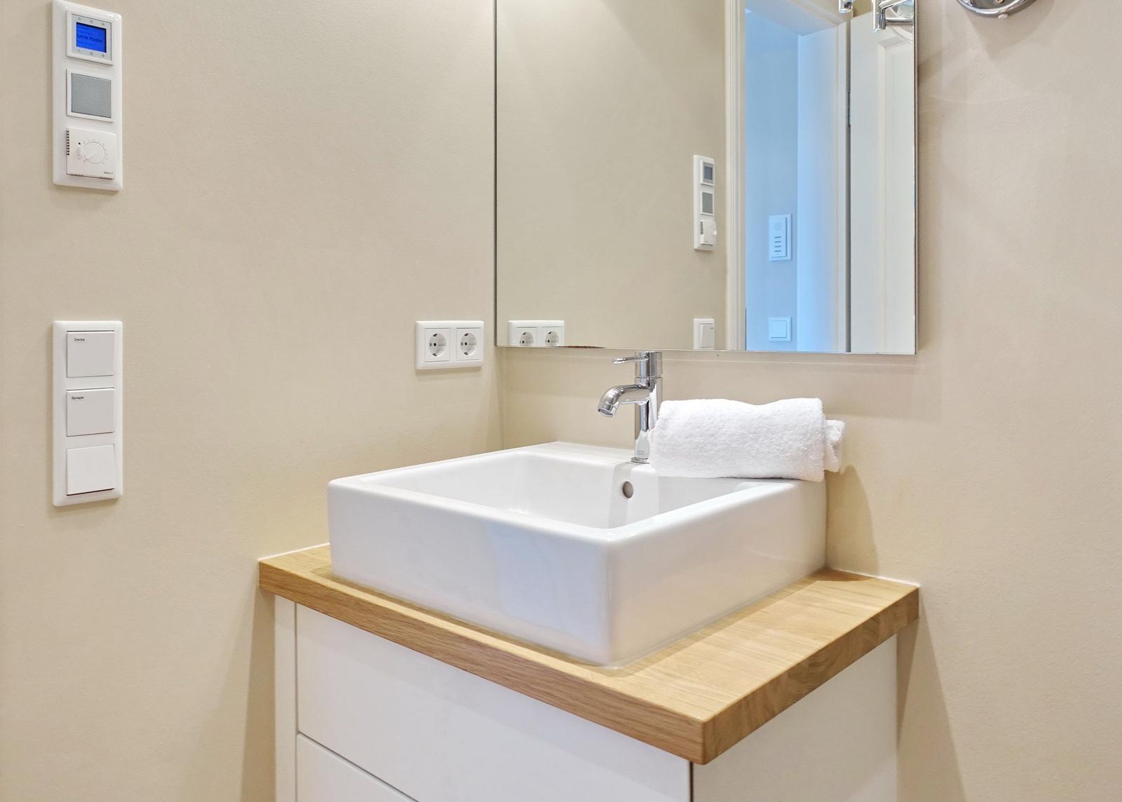 Sink with mirror and towel on wooden top