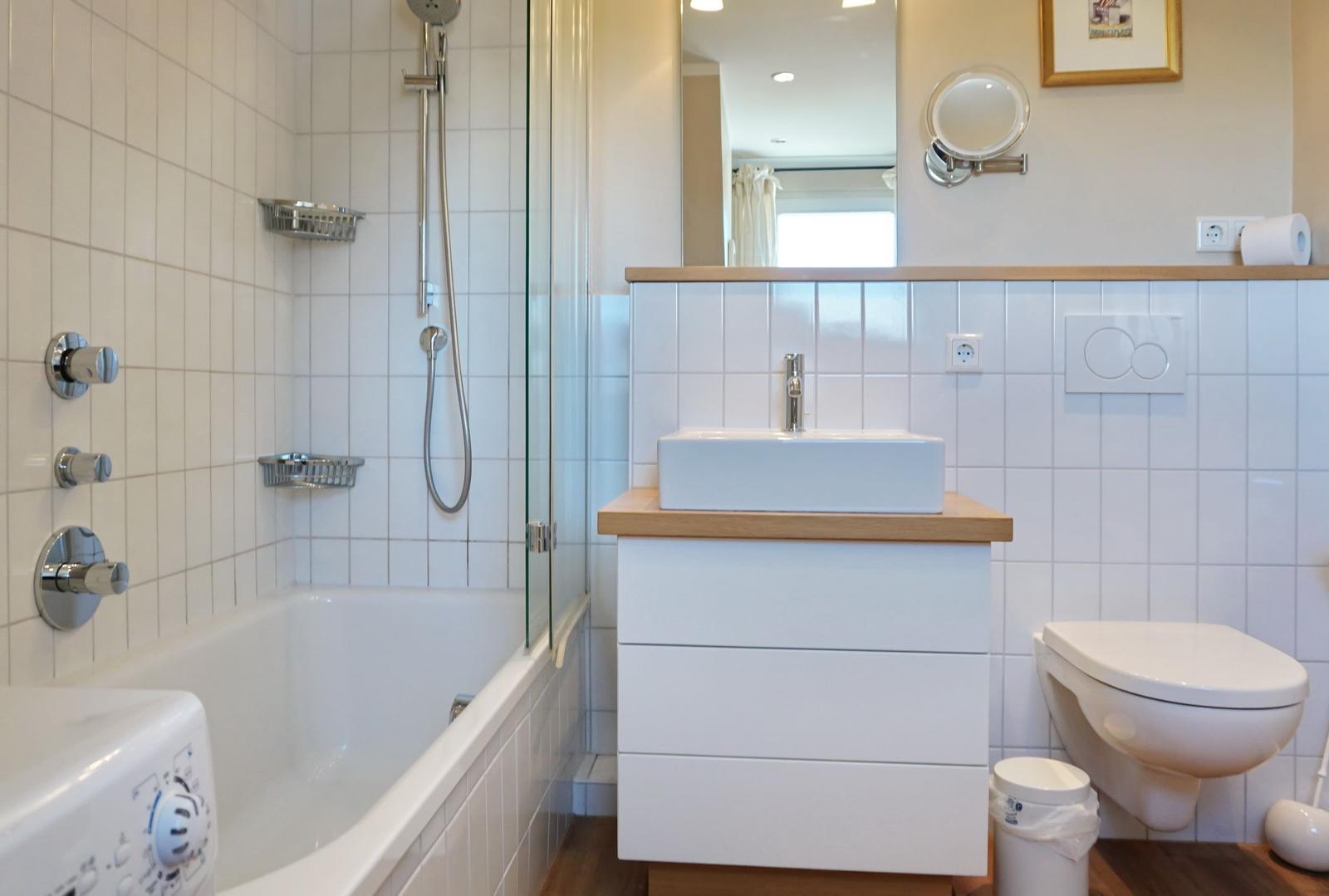 Bathroom with bathtub, shower, sink, and toilet.
