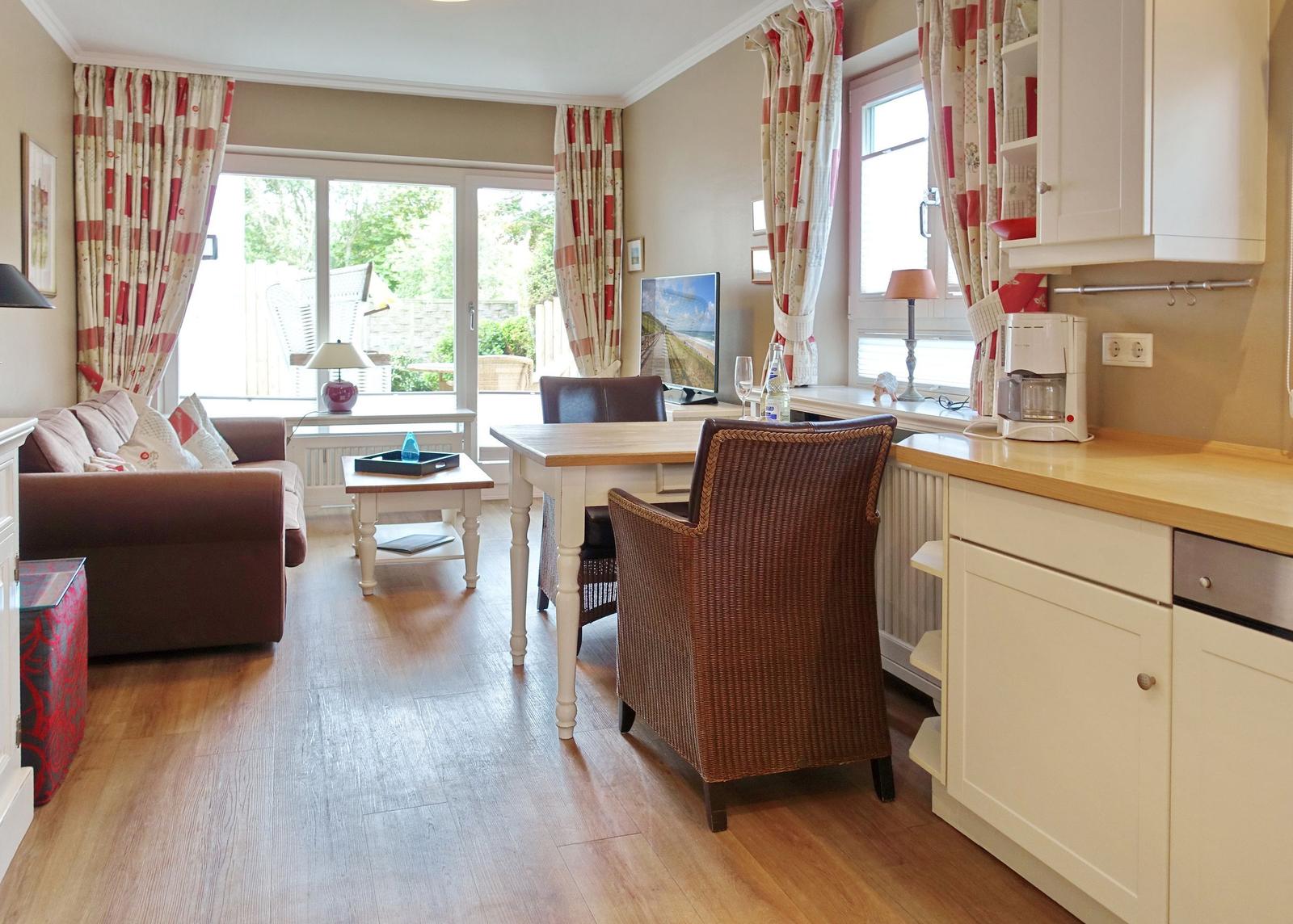 Living and dining area with kitchenette and view of the garden.