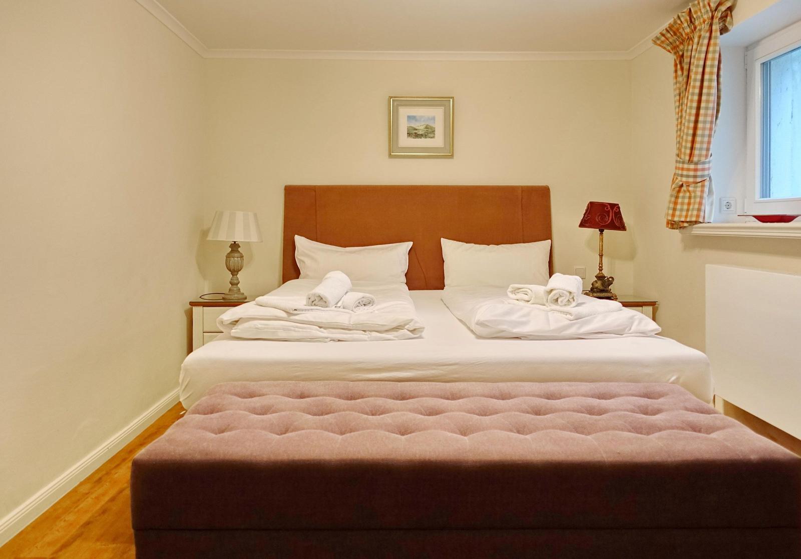 Double bed with white bedding and two nightstands with lamps.