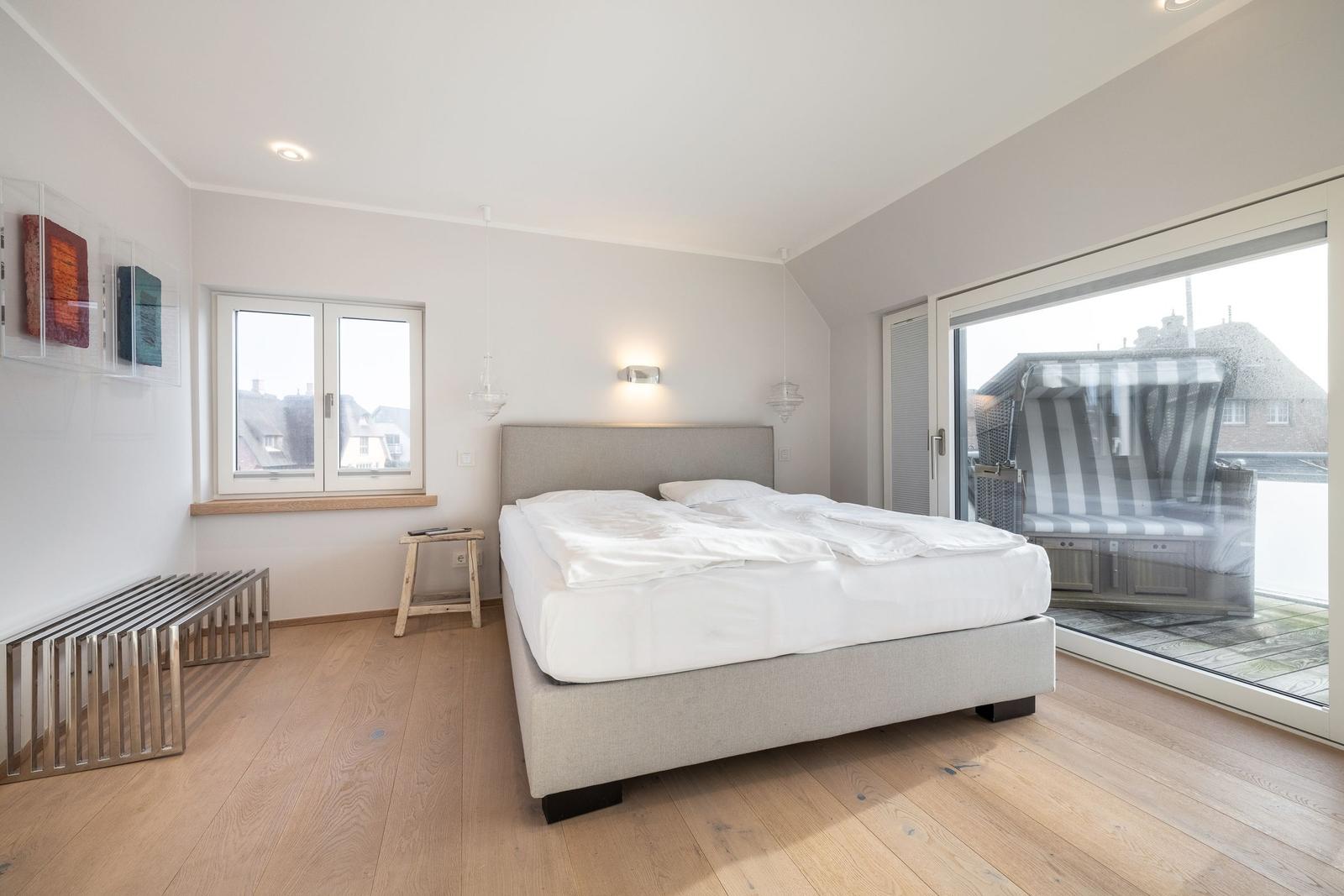 Bedroom with bed, window, and glass door to terrace.