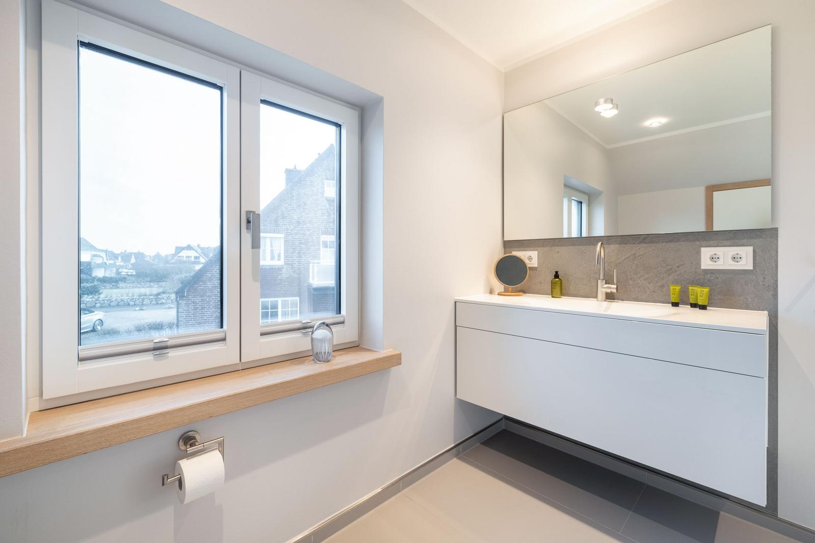 Bathroom with window, sink, and mirror