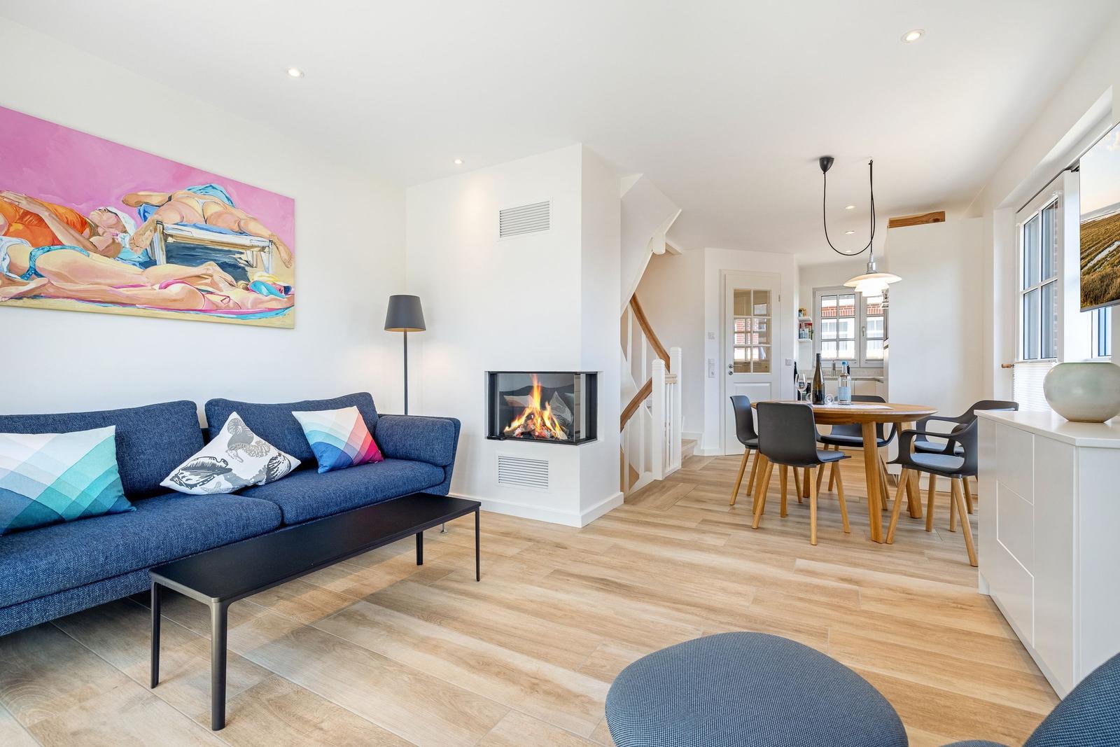 Wohn- und Essbereich mit Kamin, Sofa und Holzboden.