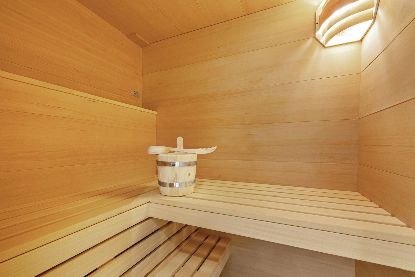 Sauna mit Holzbank und Eimer mit Löffel