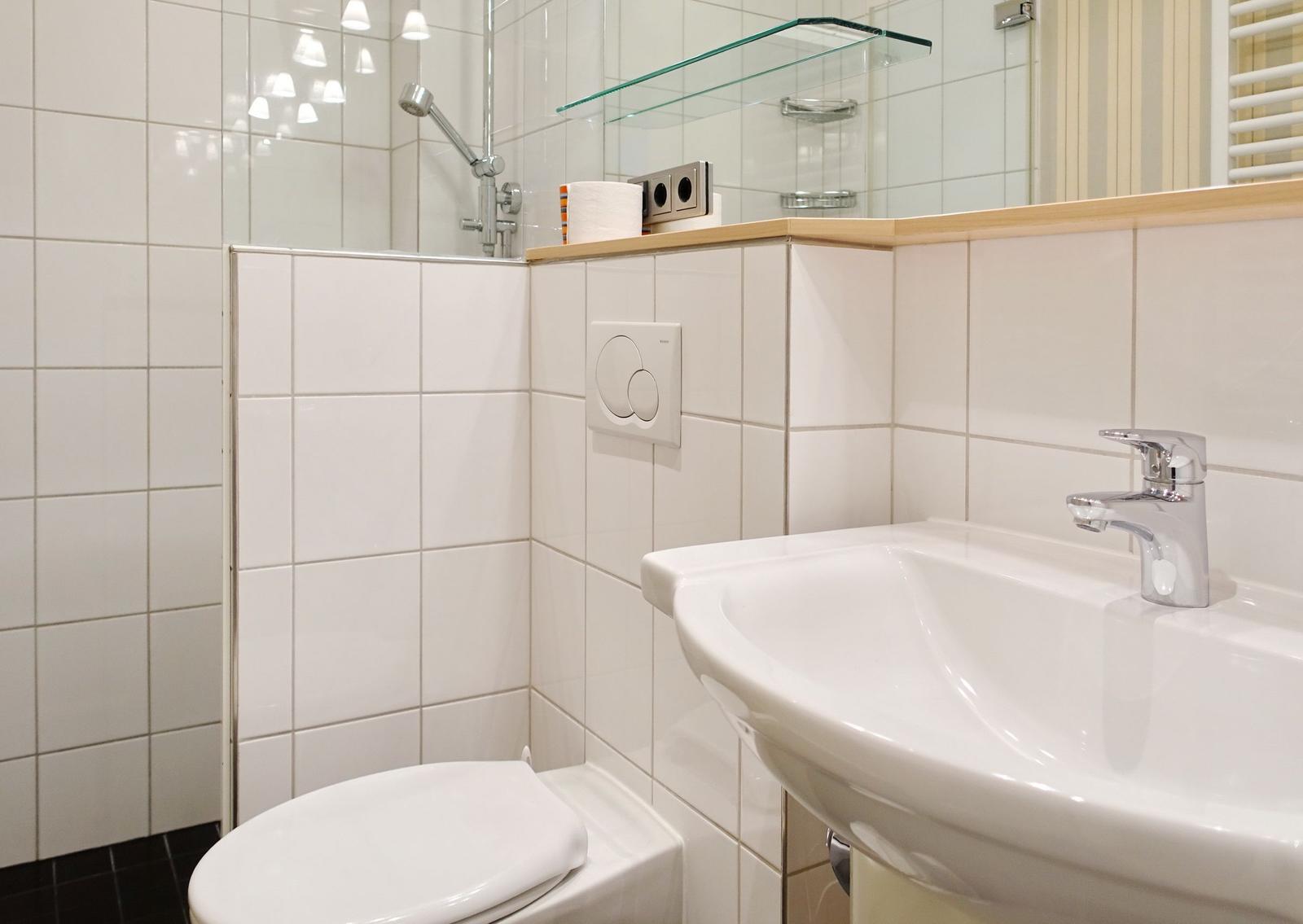 Bathroom with sink, toilet, and shower.