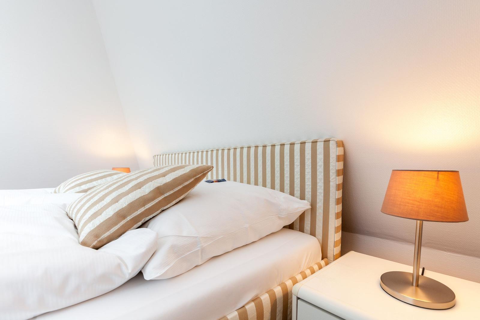 Double bed with pillows and nightstand with lamp