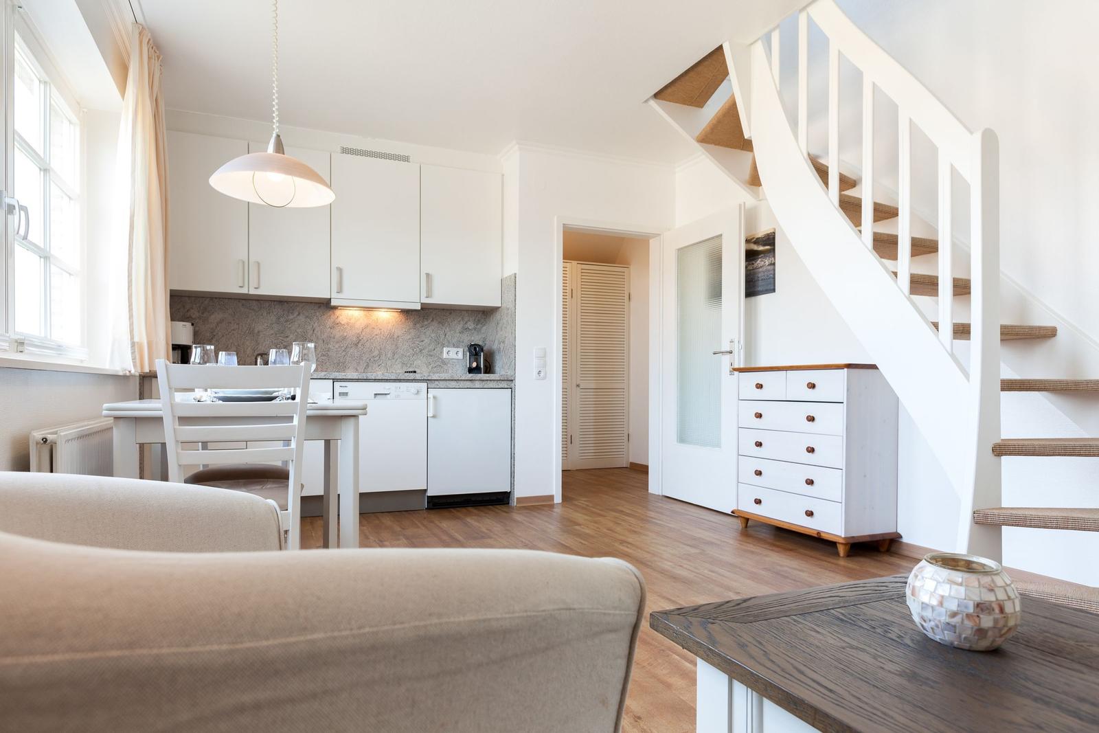Apartment with kitchen, dining area, and staircase to upper level.