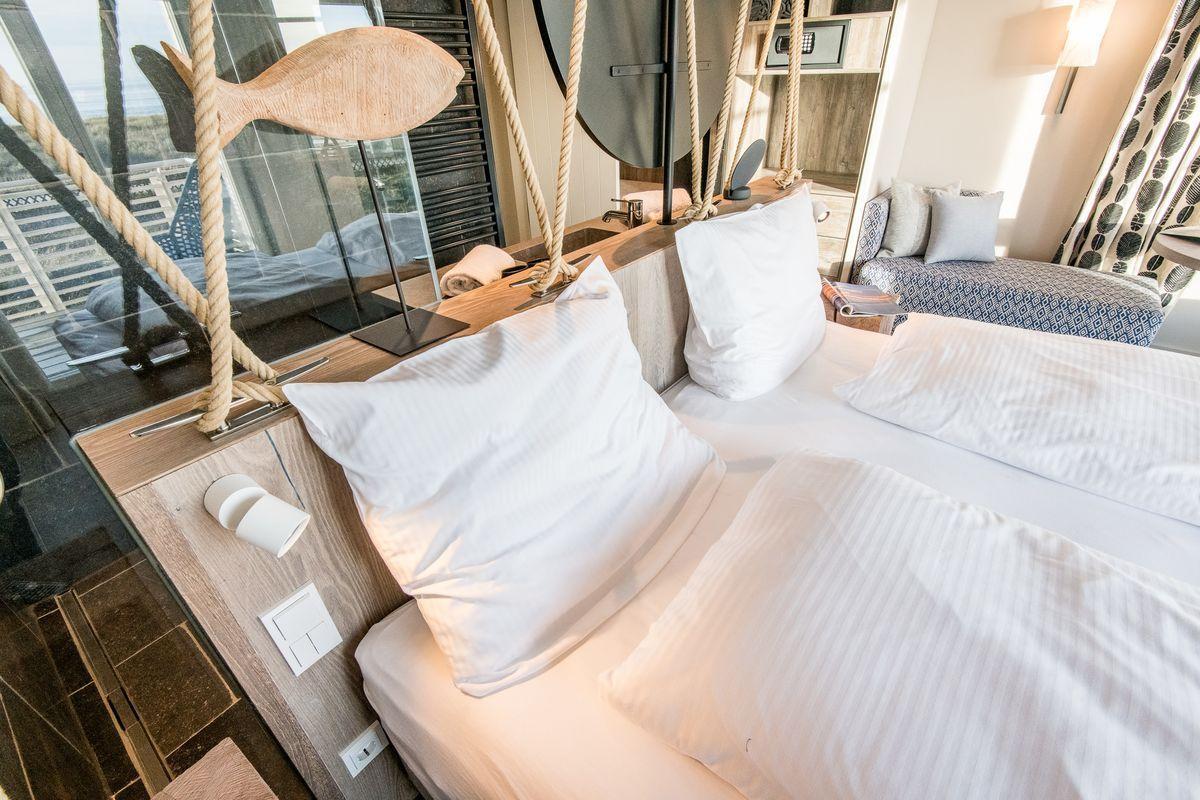 Schlafzimmer mit Bett, Kopfkissen und Fensterblick.