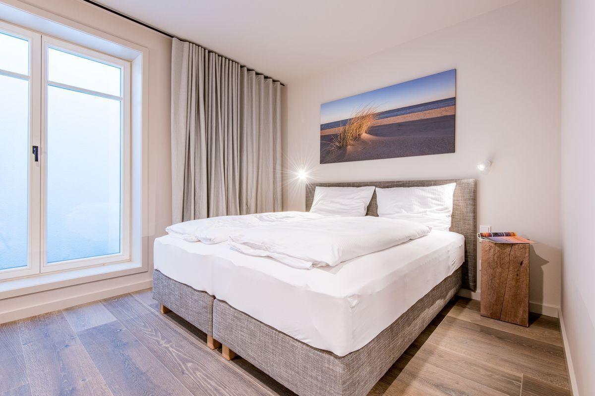 Schlafzimmer mit Doppelbett, Fenster und Wandbild