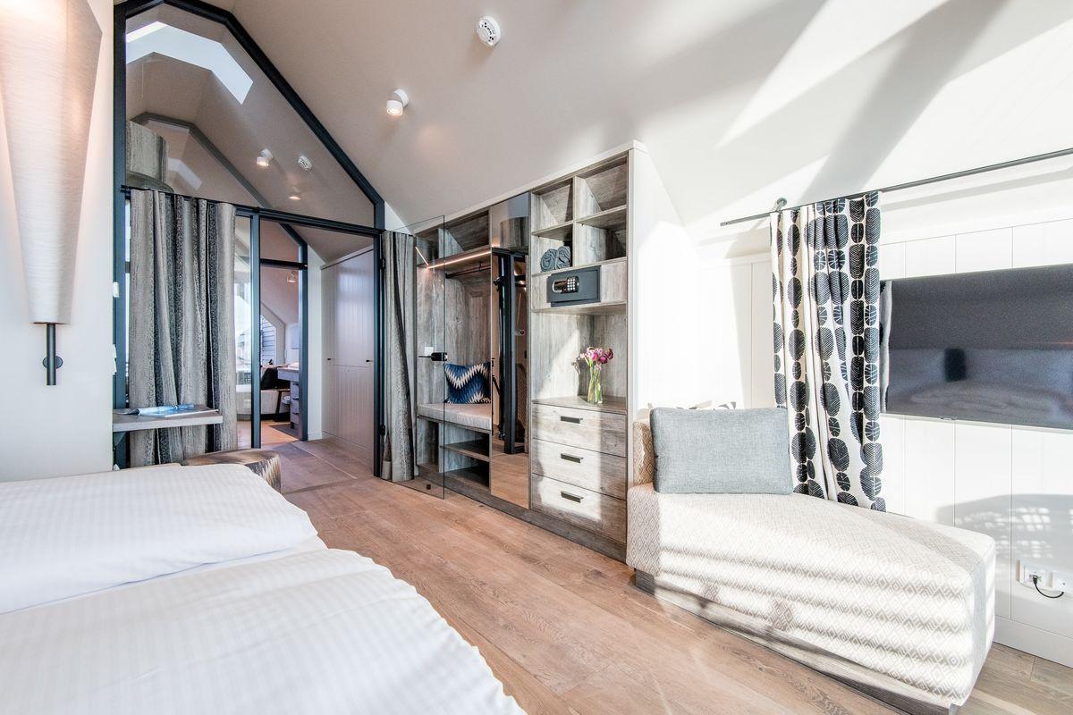Schlafzimmer mit Doppelbett, Sitzbank und integriertem Schrank.