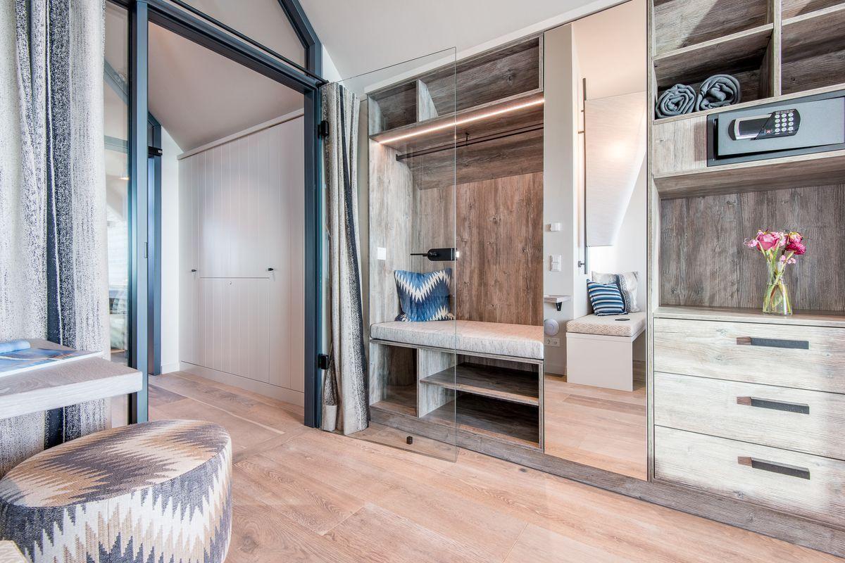 Schlafzimmer mit Glaswand, Holzmöbel und integriertem Schrank.