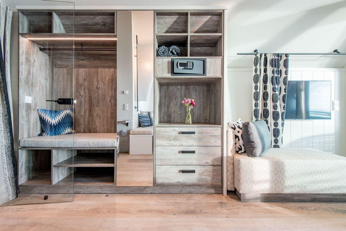 Schlafzimmer mit integriertem Schrank, Safe und Sitzbank.