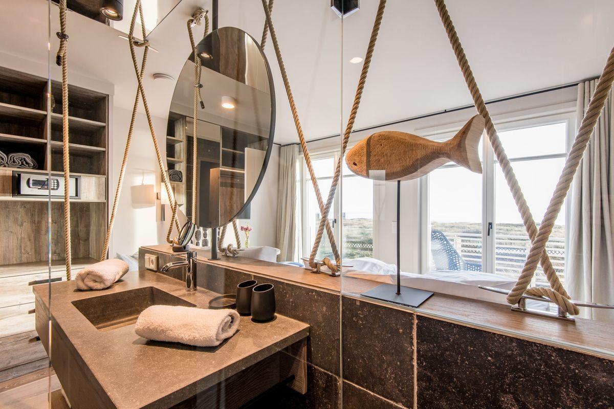 Badezimmer mit Seildekoration, Spiegel und Aussicht.