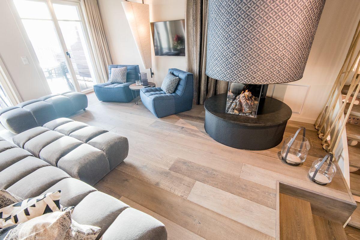 Wohnzimmer mit Sofa, Sesseln und Kamin